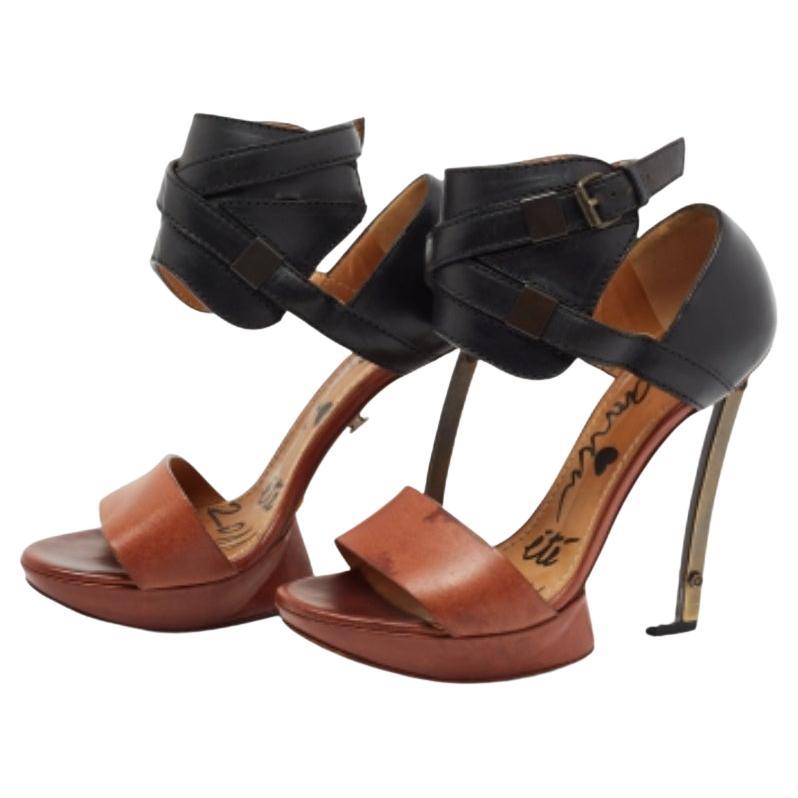 These stunning sandals by Lanvin are designed to elevate your look instantly. They are crafted from leather and designed with open toes, cuff-like ankle straps, and transparent wedge heels. An artistic pair that is worth the buy.