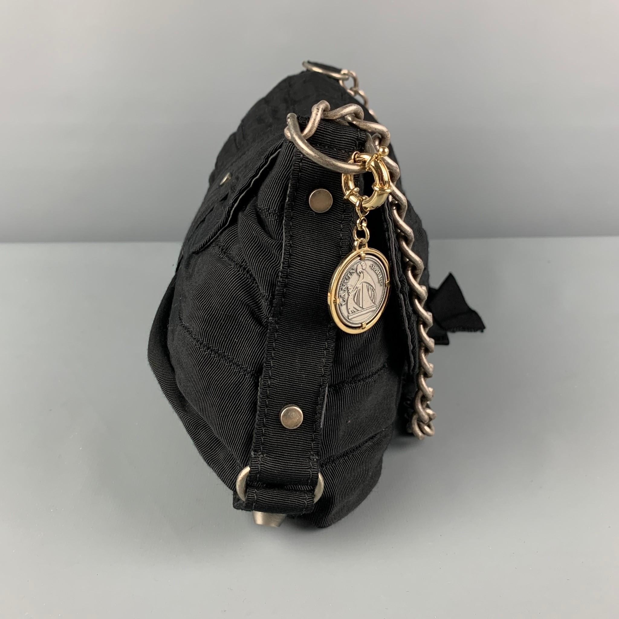 LANVIN handbag comes in a black textured fabric featuring a chain strap, ribbon detail, detachable charm, inner slot, and a push open lock. Made in Italy. 

Very Good Pre-Owned Condition. Light wear. As-Is.

Measurements:

Length: 12 in.
Height: 7