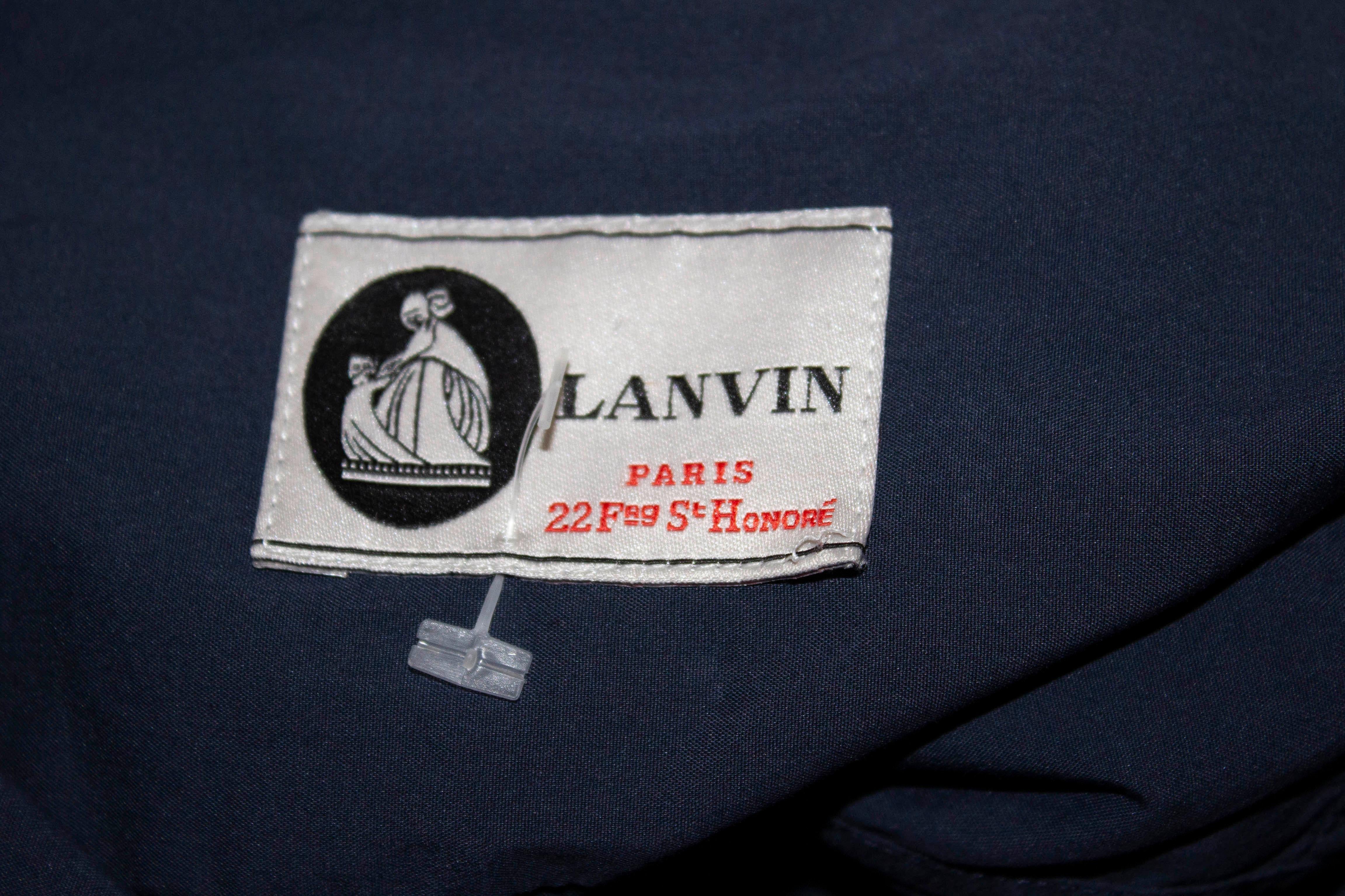 Une chemise facile à porter pour l'été  par Lanvin. La chemise a un col blanc et un corps bleu. Il est sans manches, s'ouvre par un bouton sur le devant et comporte des fentes de chaque côté.
Taille 42 (italienne) Poitrine jusqu'à 41'', longueur