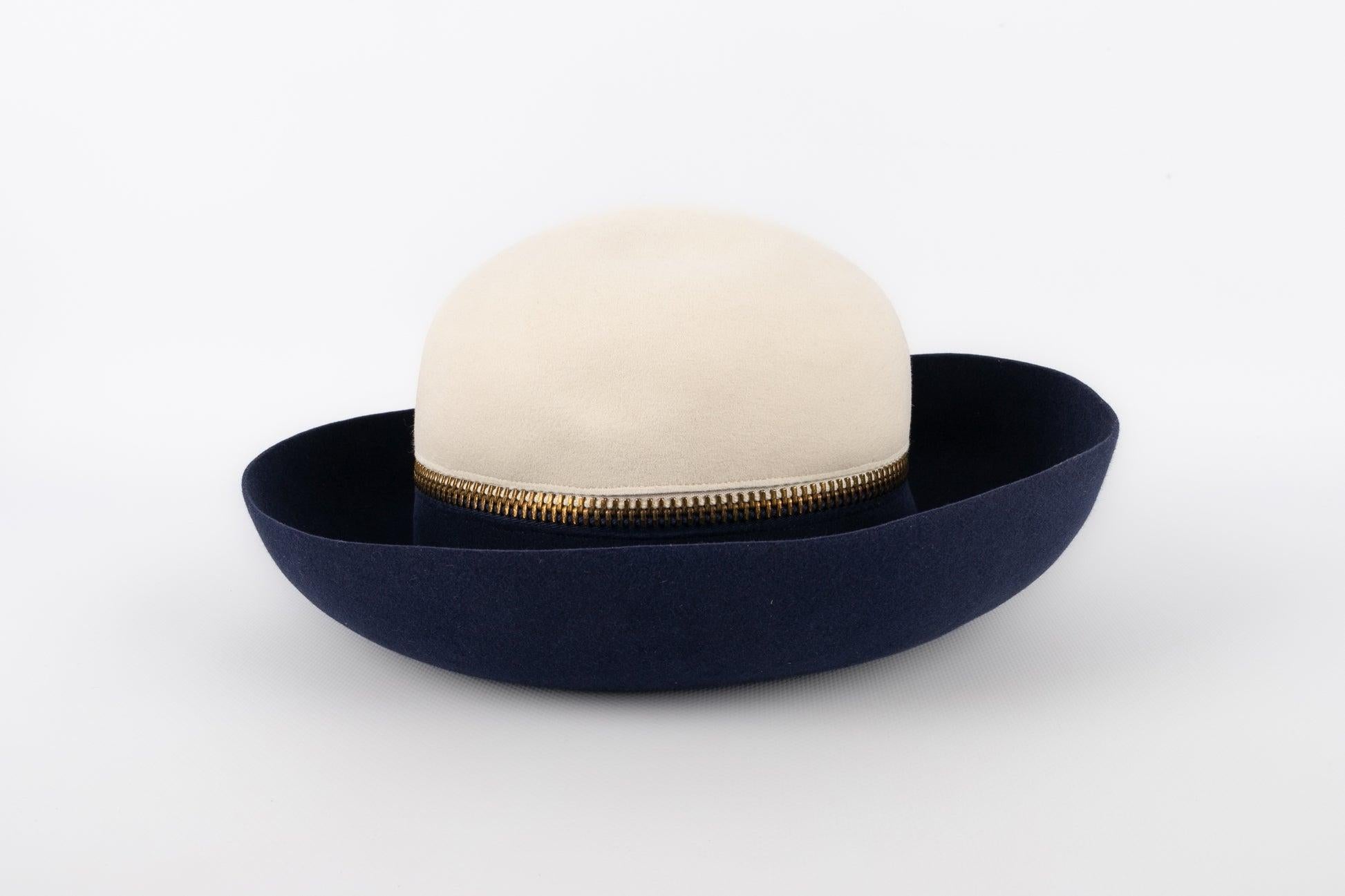 Lanvin - (Made in France) Blue and white felt hat ornamented with a golden metal zipper.

Additional information: 
Condition: Very good condition
Dimensions: Head circumference: 51 cm

Seller Reference: CHP30