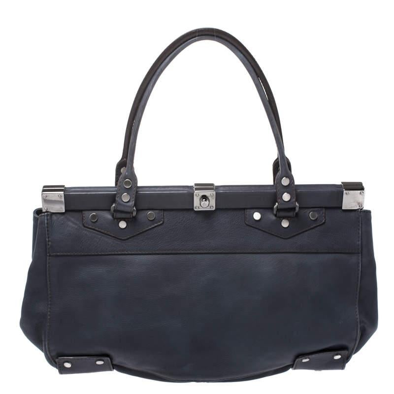 This well-designed satchel from Lanvin is crafted from blue leather with silver-tone metal framed top. The exterior of the bag is adorned with metal studs and a zipped pocket to the front. It has a fabric-lined interior where you can house all your