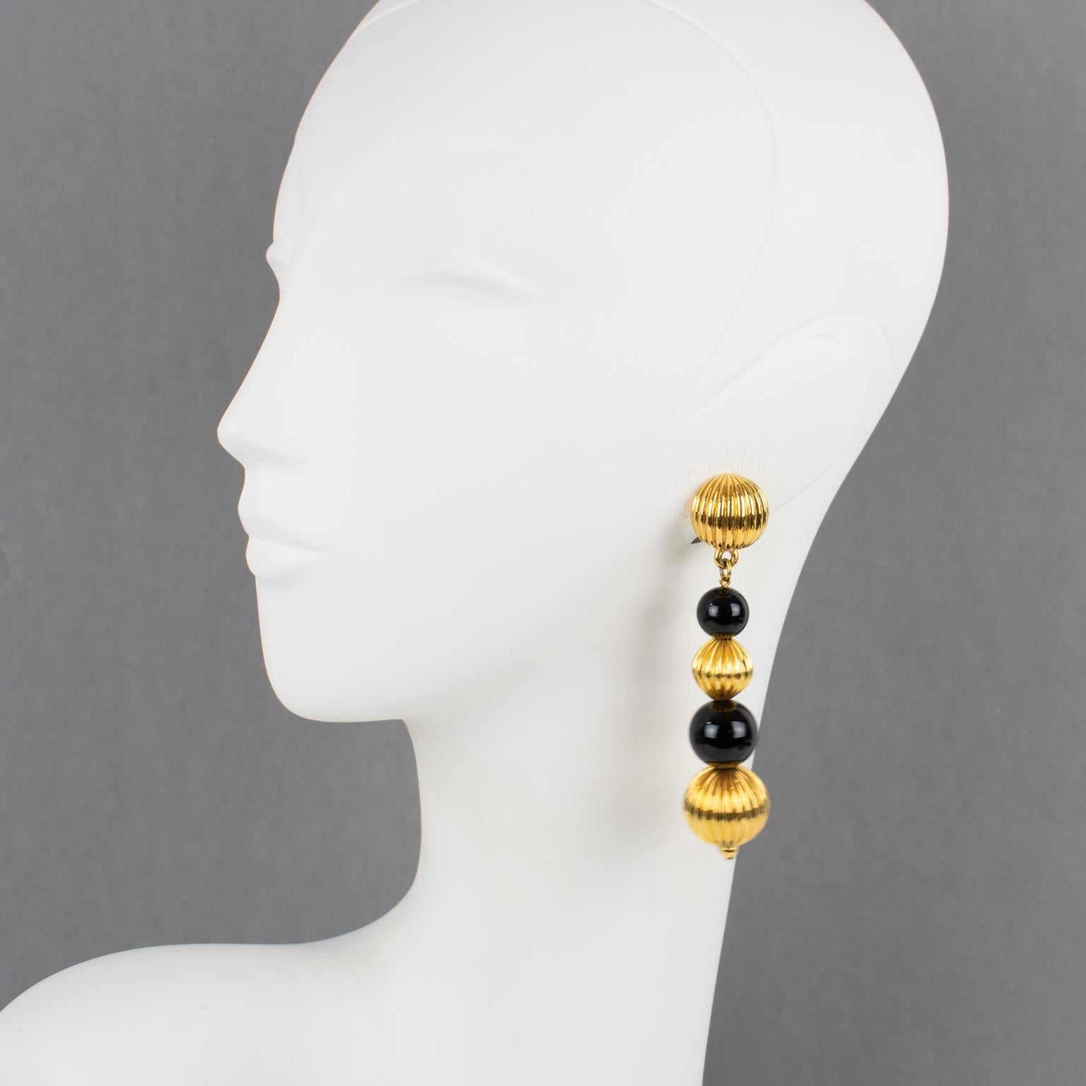 Questi rari ed eleganti orecchini a clip di Lanvin Paris sono caratterizzati da una lunga forma penzolante con perline in metallo dorato intagliato e perline in vetro color cacao a forma graduata. L'etichetta dorata sotto la chiusura riporta la