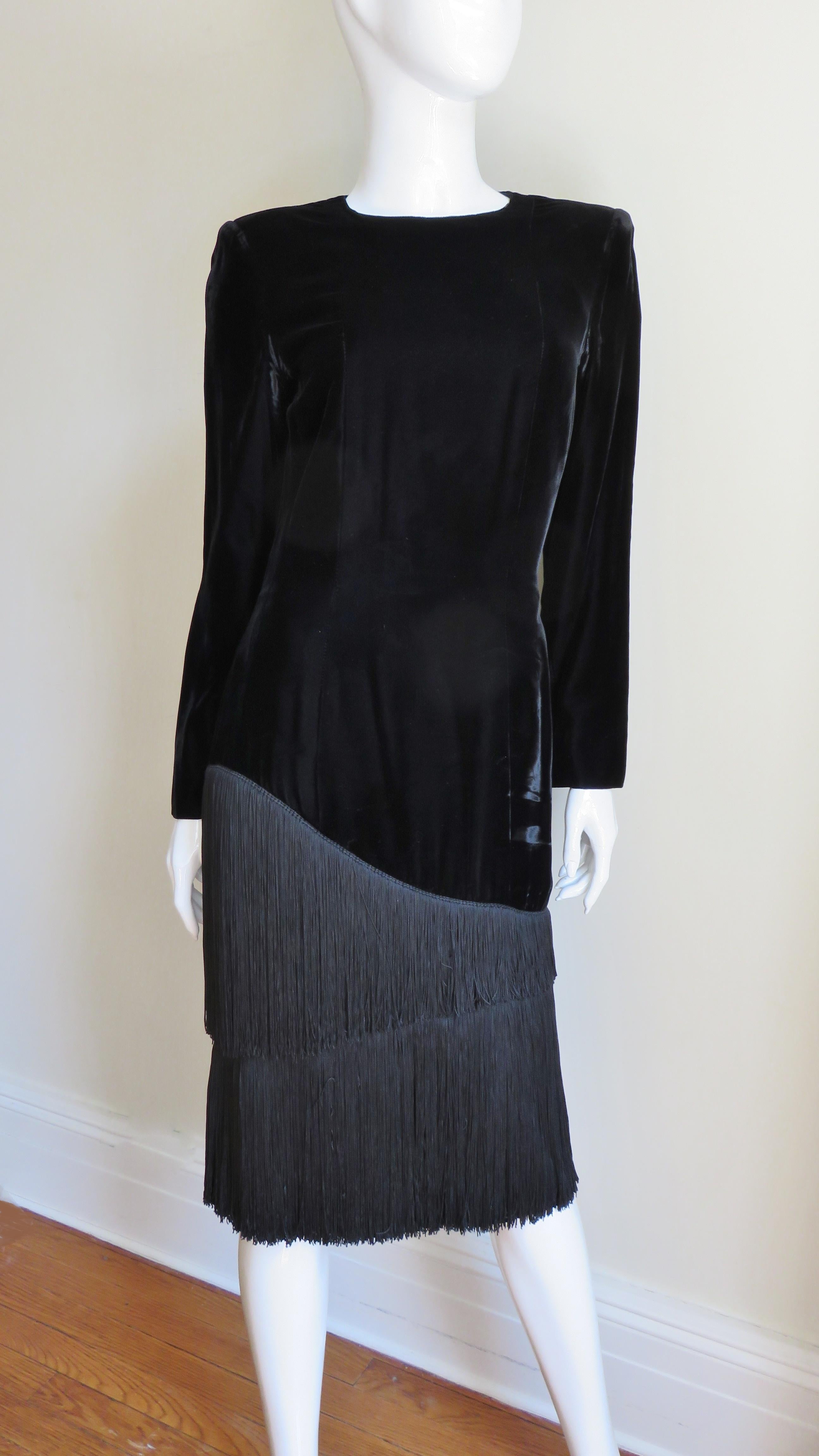 Une fabuleuse robe en velours noir de Lanvin. Il s'agit d'un fourreau simple à manches longues, avec une encolure ras du cou, semi-ajustée à la taille et tombant droit sur l'ourlet. Une rangée de franges de soie dégradées de 11-13