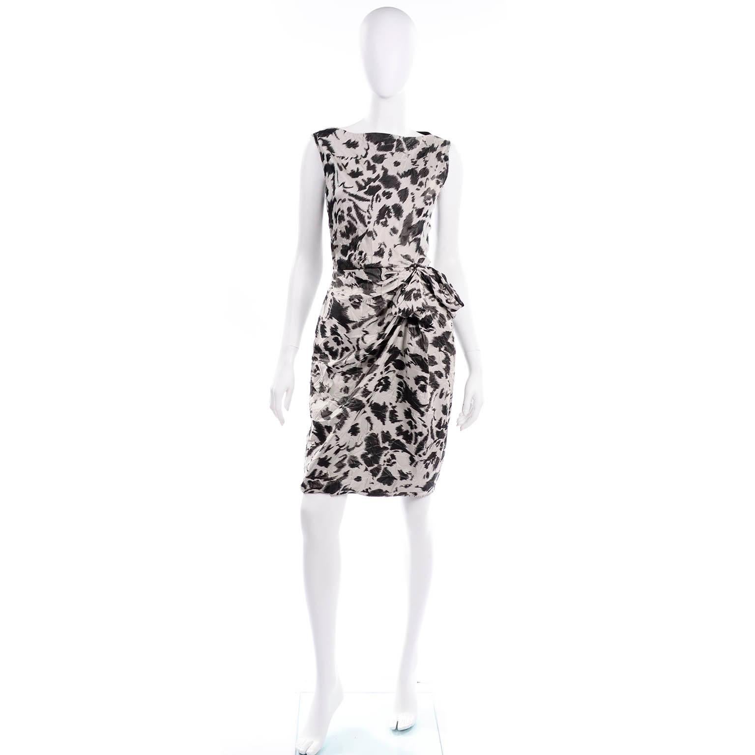 This is a lovely Lanvin summer 2011 sleeveless gray and black abstract floral print dress with intentional set in wrinkles  This dress has raw edges, draping on one side with a bow, and an external side zipper. Wear it to lunch or dinner, depending
