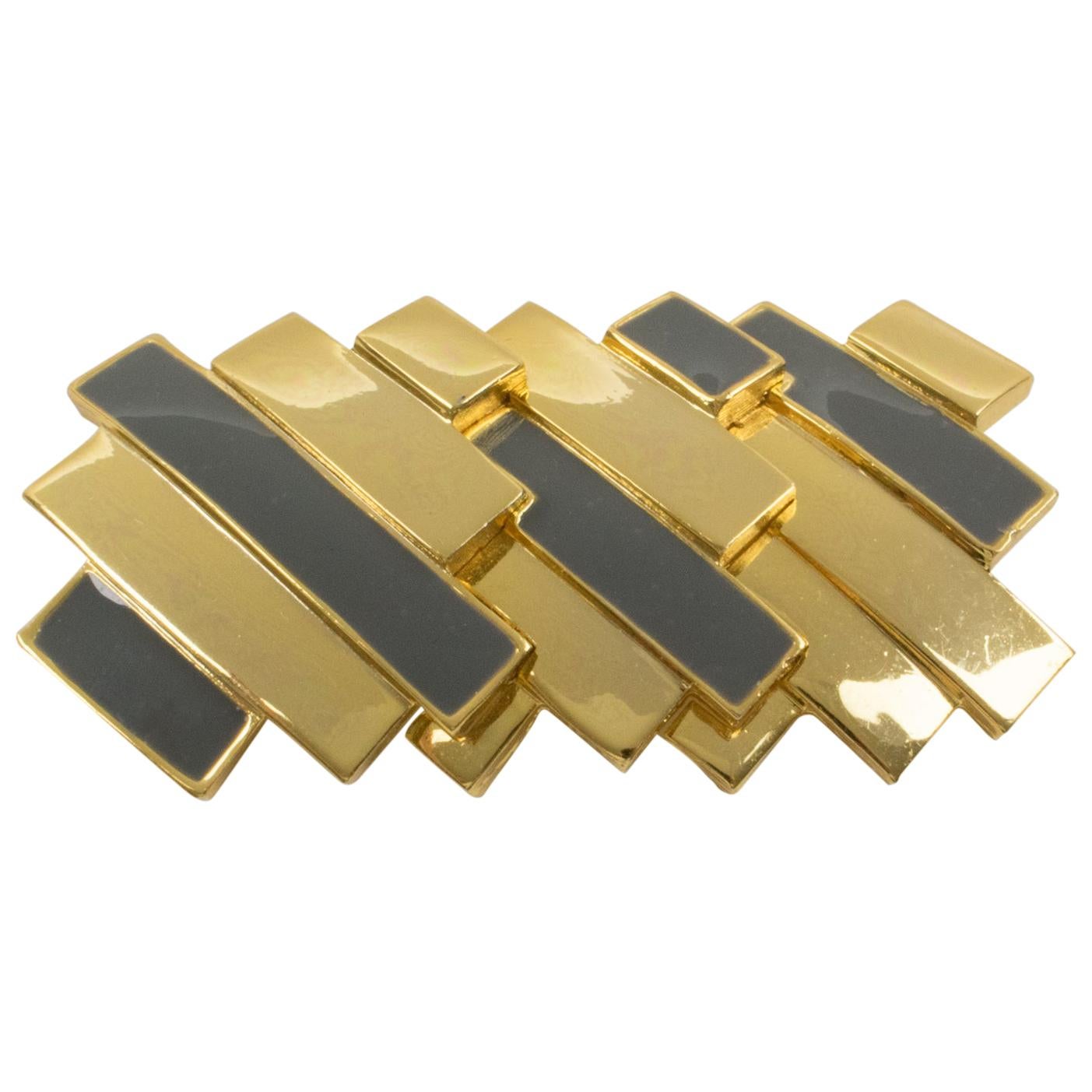 This stunning Lanvin Paris modernist pin brooch is a statement piece from the early 1970s. It features a massive gilded metal carved design in a futuristic geometric and three-dimensional shape, complemented with gray enamel. The security closing