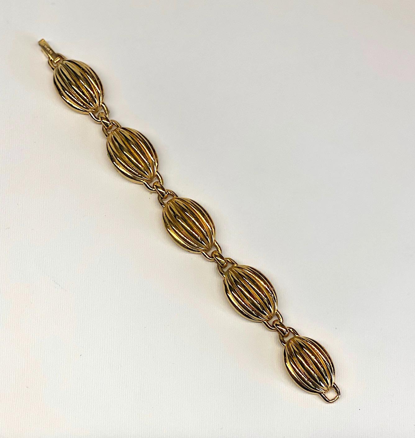 A beautiful dome link Lanvin bracelet from the 1980s. The five links are cast in a dome shape with six deep ribs or scallops with a ring at each end. A single small oval link connects each larger ones. The bracelet measures .75 of an inch wide, .5