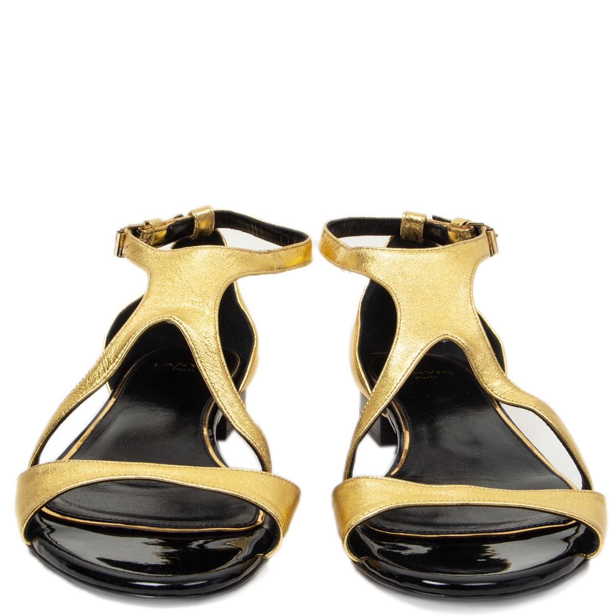 100% authentische Lanvin flache Sandalen mit Knöchelriemen aus goldfarbenem Metallic-Leder und schwarzem Lackleder an der Spitze. Wurden einmal innen getragen und sind in praktisch neuem Zustand.  

Messungen
Aufgedruckte