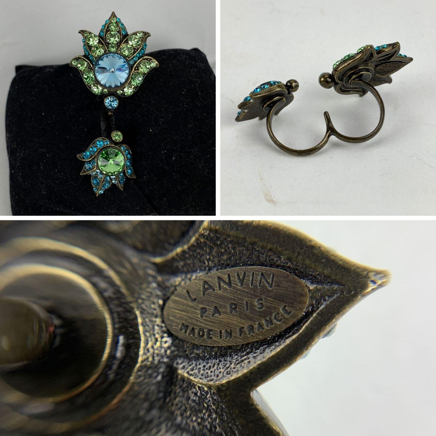 Lanvin's crystal-embellished ring is designed to sit across two fingers. The gold-tone brass bands give this striking adornment an elegant, vintage feel. Green and turquoise crystals. 'LANVIN Paris - Made in France' oval tag on the reverse of the