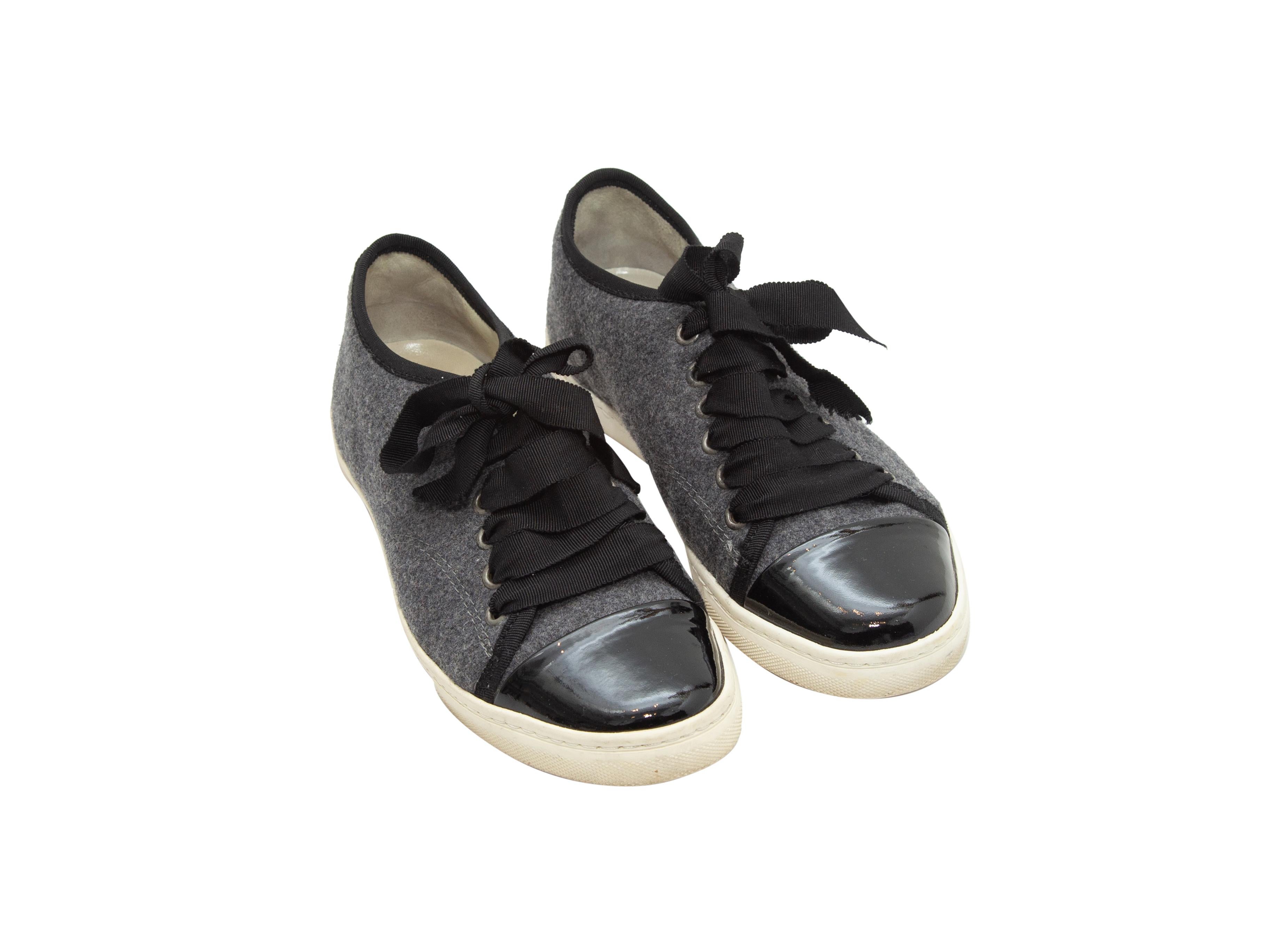 Product details: Grey wool and black patent leather cap-toe low-top sneakers by Lanvin. Rubber soles. Lace-up tie closures at tops. Designer size 36.5.
Condition: Pre-owned. Very good. Wear at soles. Slight wear at inner soles.