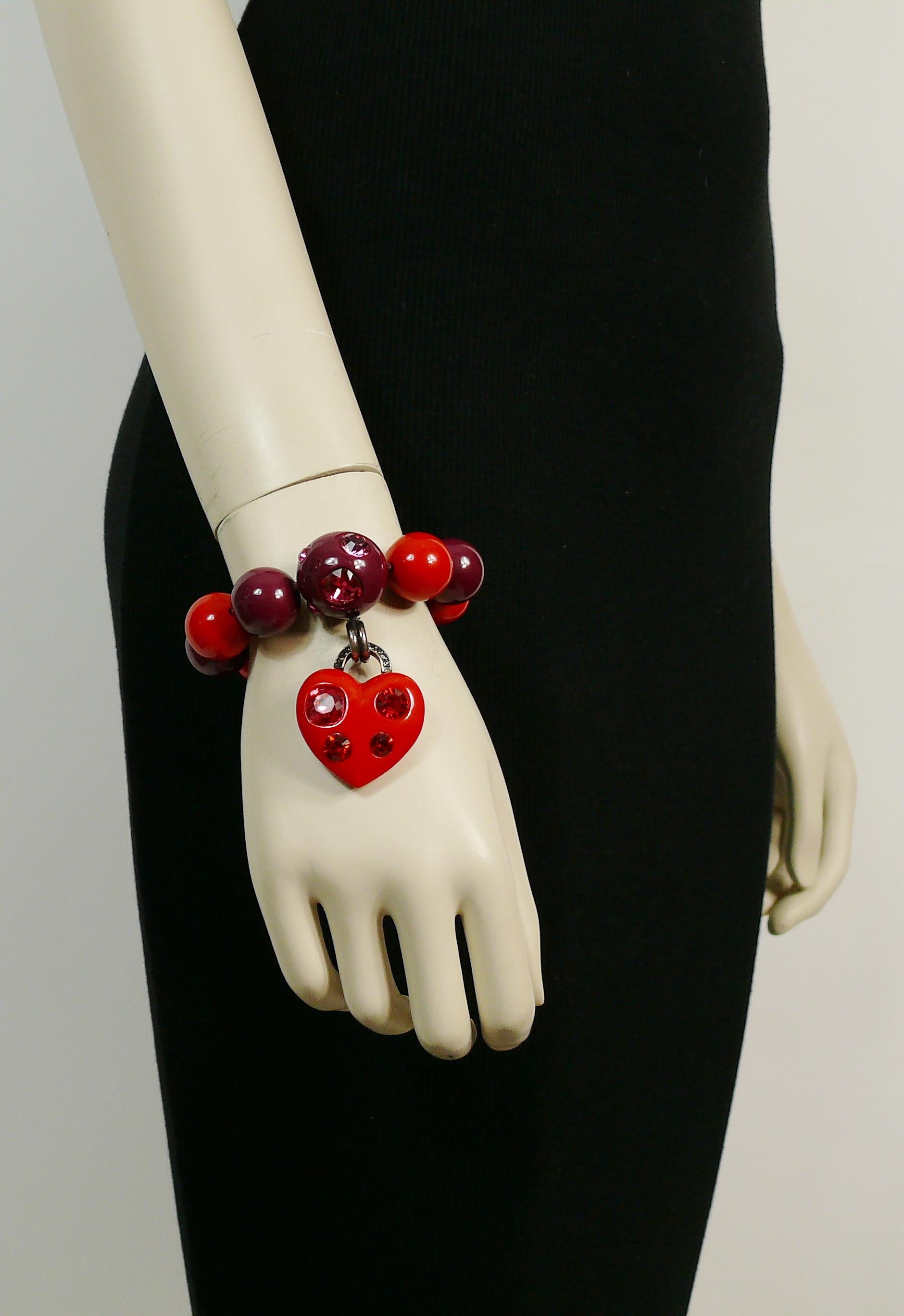 LANVIN heart charm bracelet featuring purple and red resin beads embellished with Swarovski crystals.

Elasticated.
Slips on.

Embossed LANVIN Paris.
Made in Italy.

Indicative measurements : inner circumference (unstretched) approx. 14.15 cm (5.57