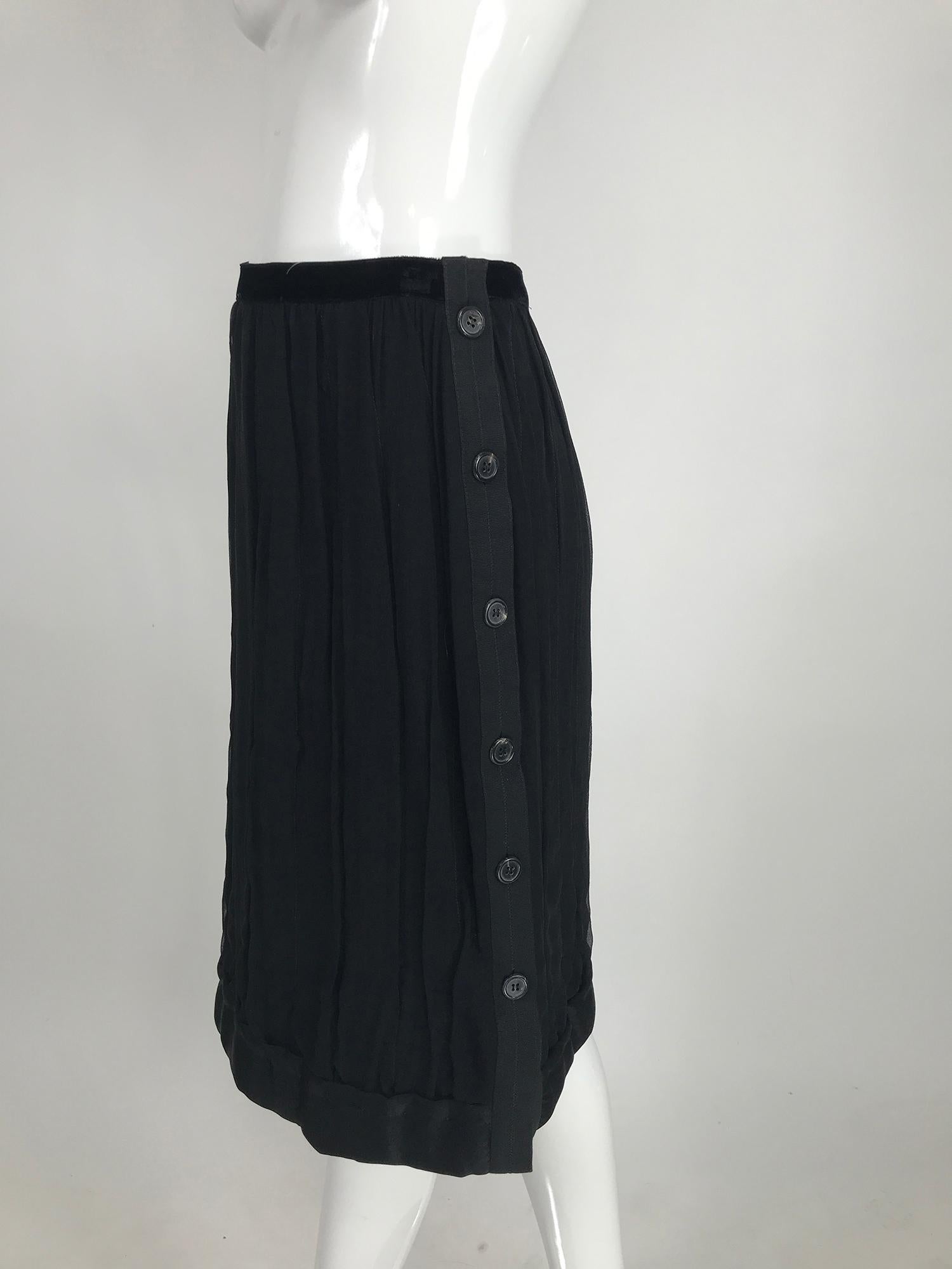 Lanvin black silk chiffon skirt has a velvet waist band and padded silk satin hem band, the chiffon of the skirt is draped vertically over a silk knit lining. This unique skirt closes at the side with buttons from the waist to the hem. Fully lined.