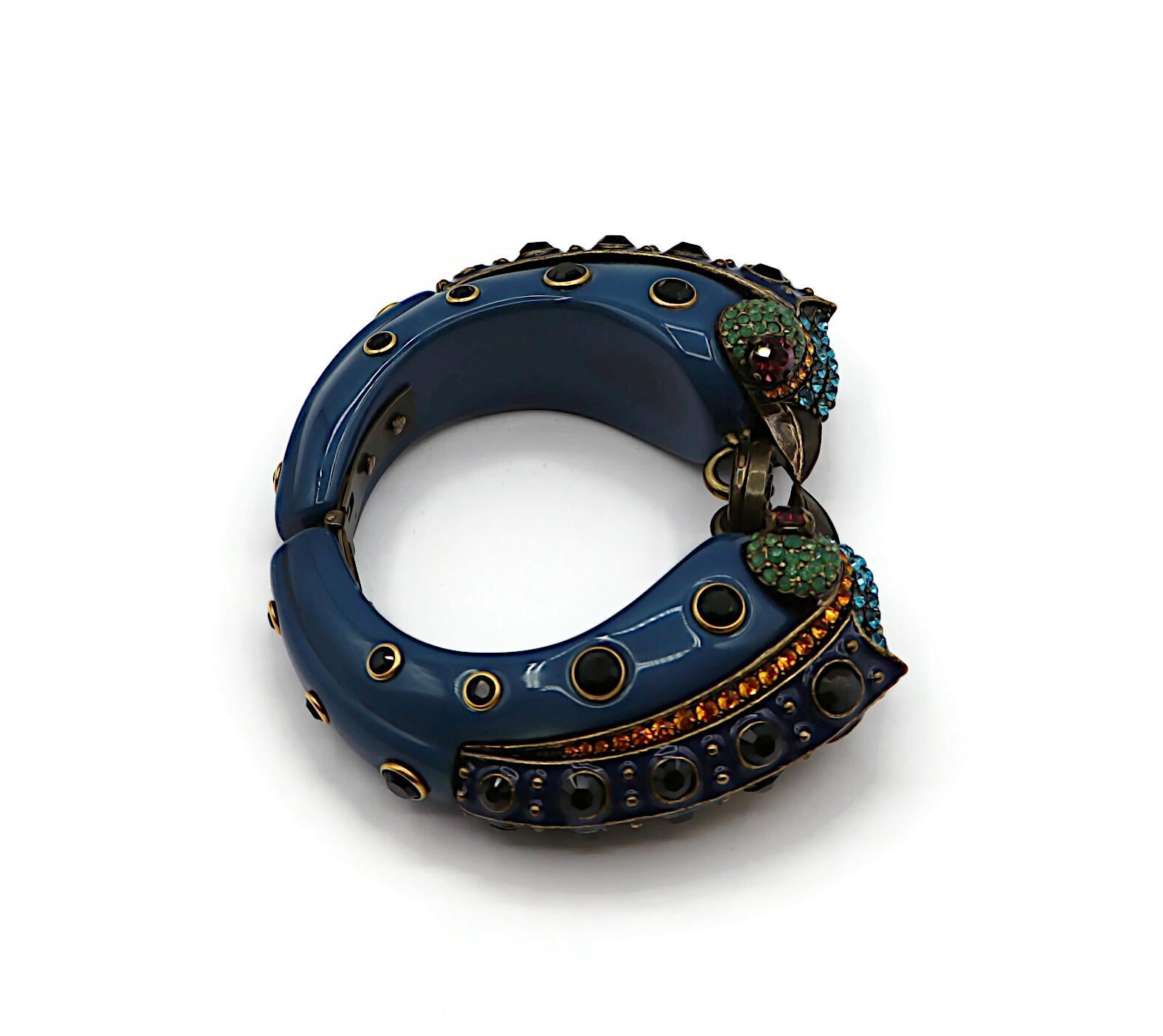 LANVIN - Bracelet à charnière à double oiseau en laque bleue, orné de cristaux multicolores.

Fermeture par crochet et œillet.

Embossé LANVIN Paris.
Fabriqué en France.

Mesures indicatives : circonférence intérieure environ 16,34 cm (6,43 pouces)