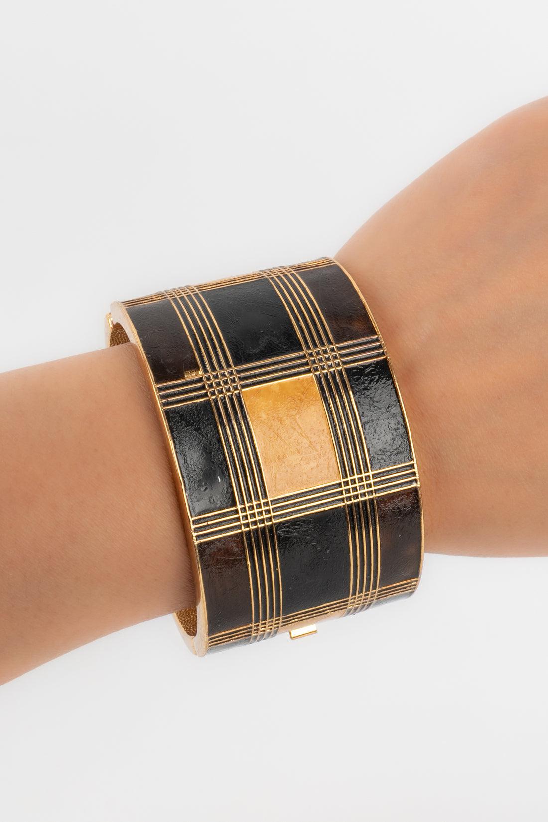 Lanvin - Bracciale in metallo dorato laccato. Da segnalare alcune crepe sullo smalto.

Informazioni aggiuntive:
Condizioni: Buone condizioni
Dimensioni: Circonferenza: 17,5 cm - Apertura: 7 cm

Riferimento del venditore: BRA174