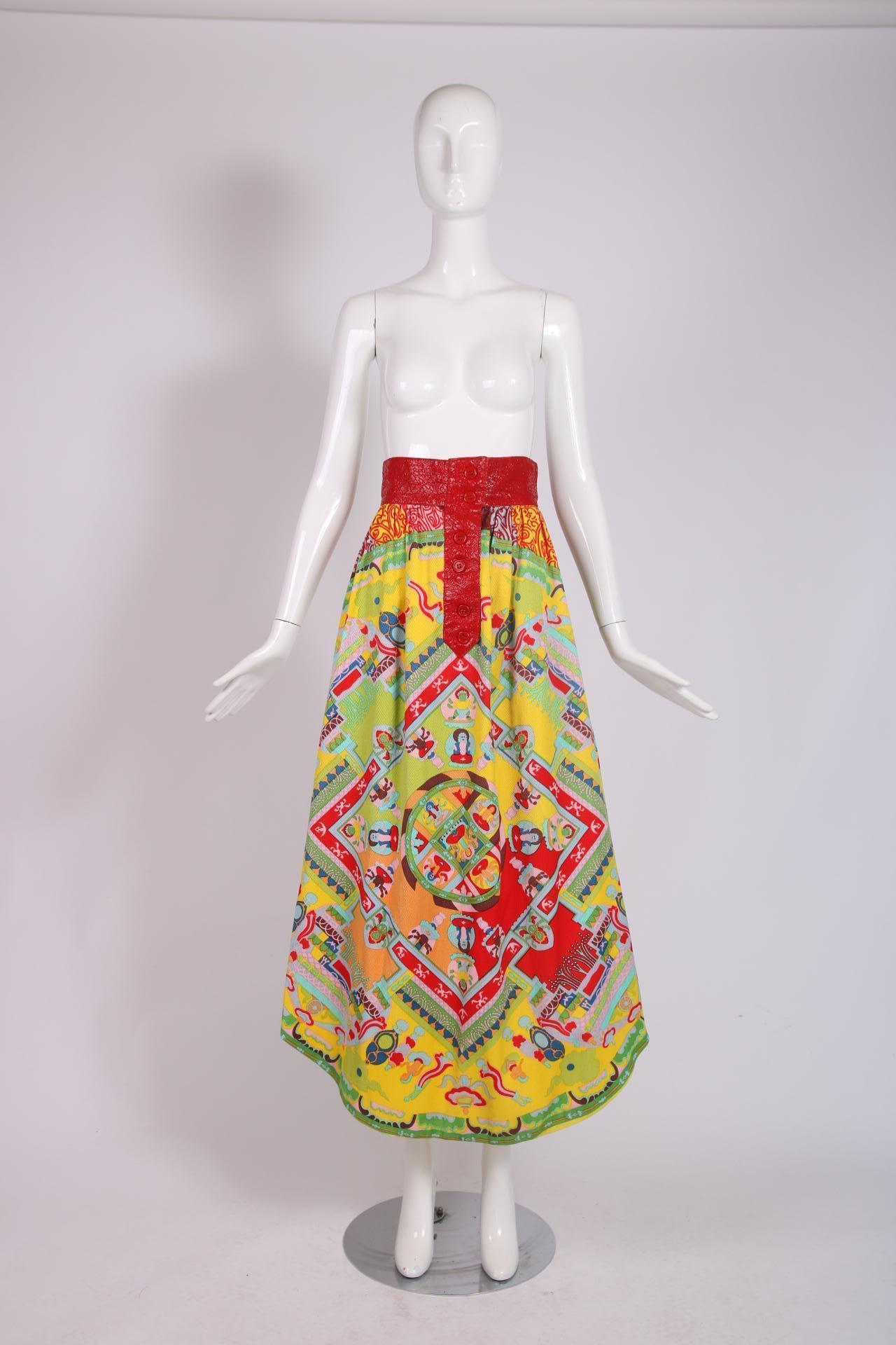 A 1970's Lanvin maxi skirt with a rounded hem, red pleather trim at the waist, red button closures just below the waist and a colorful graphic 