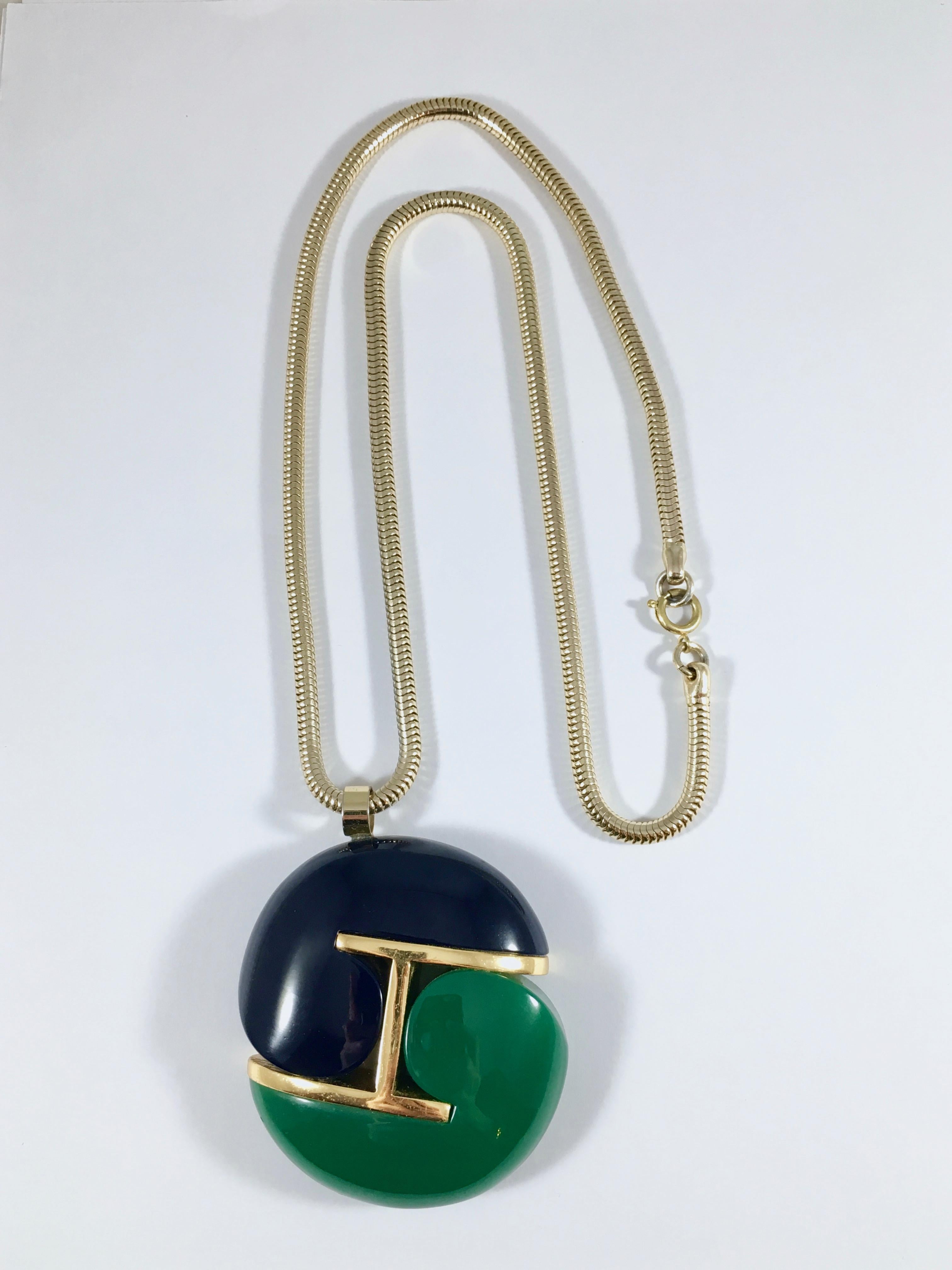 This is a fabulous unsigned Lanvin navy and green modernist pendant necklace from the late 1960s/early 1970s. The large pendant is made out of two comma shaped resin pieces and hangs from an 24 inch long goldtone snake chain. The pendant measures 2