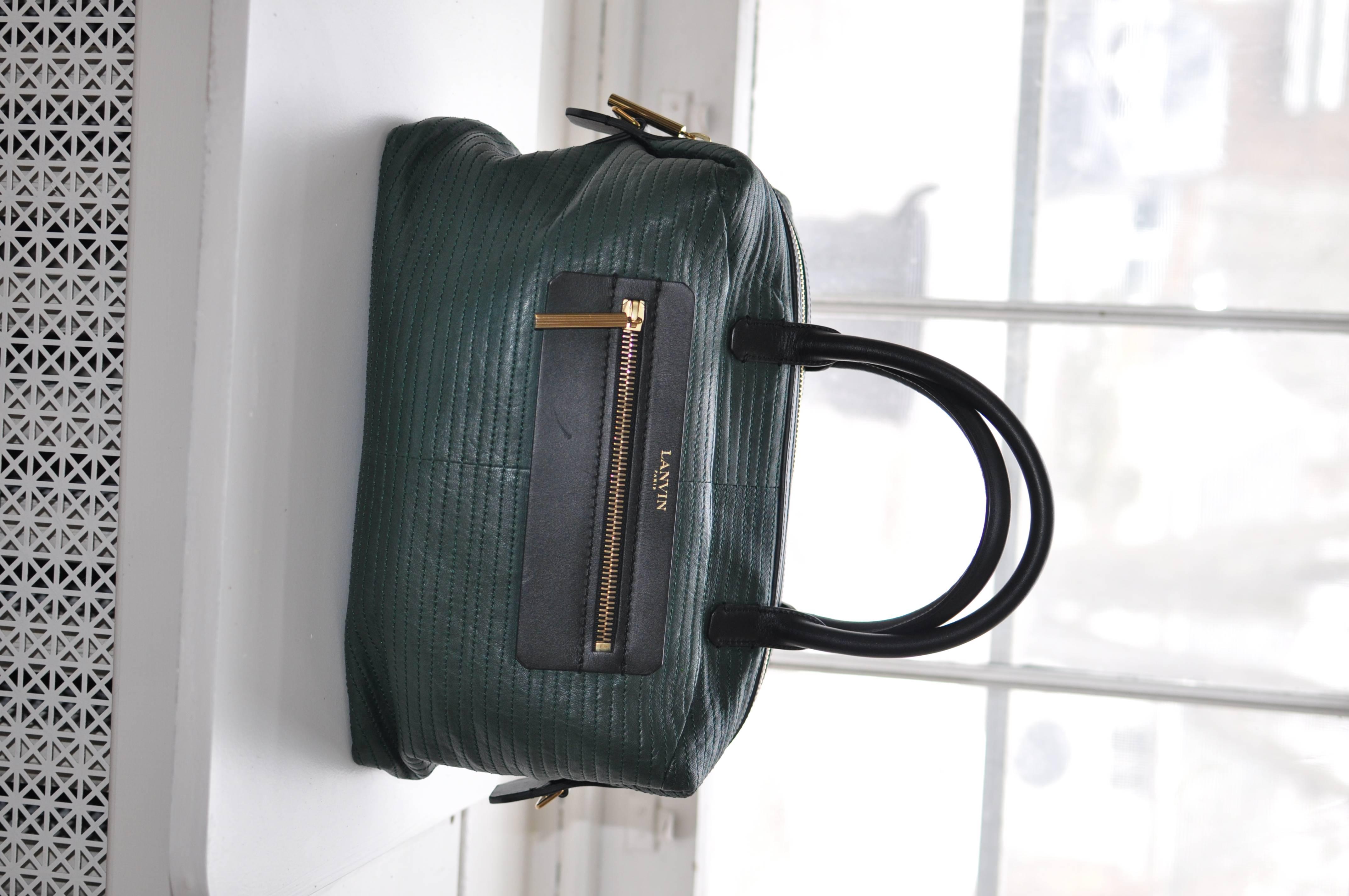 This is a really lovely bag in excellent condition in and out. It has a zipped feature pocket in front in a contrasting black as well as snap closure pocket on the back. The lining as a zipped pocket as well as a slit pocket. The handbag also