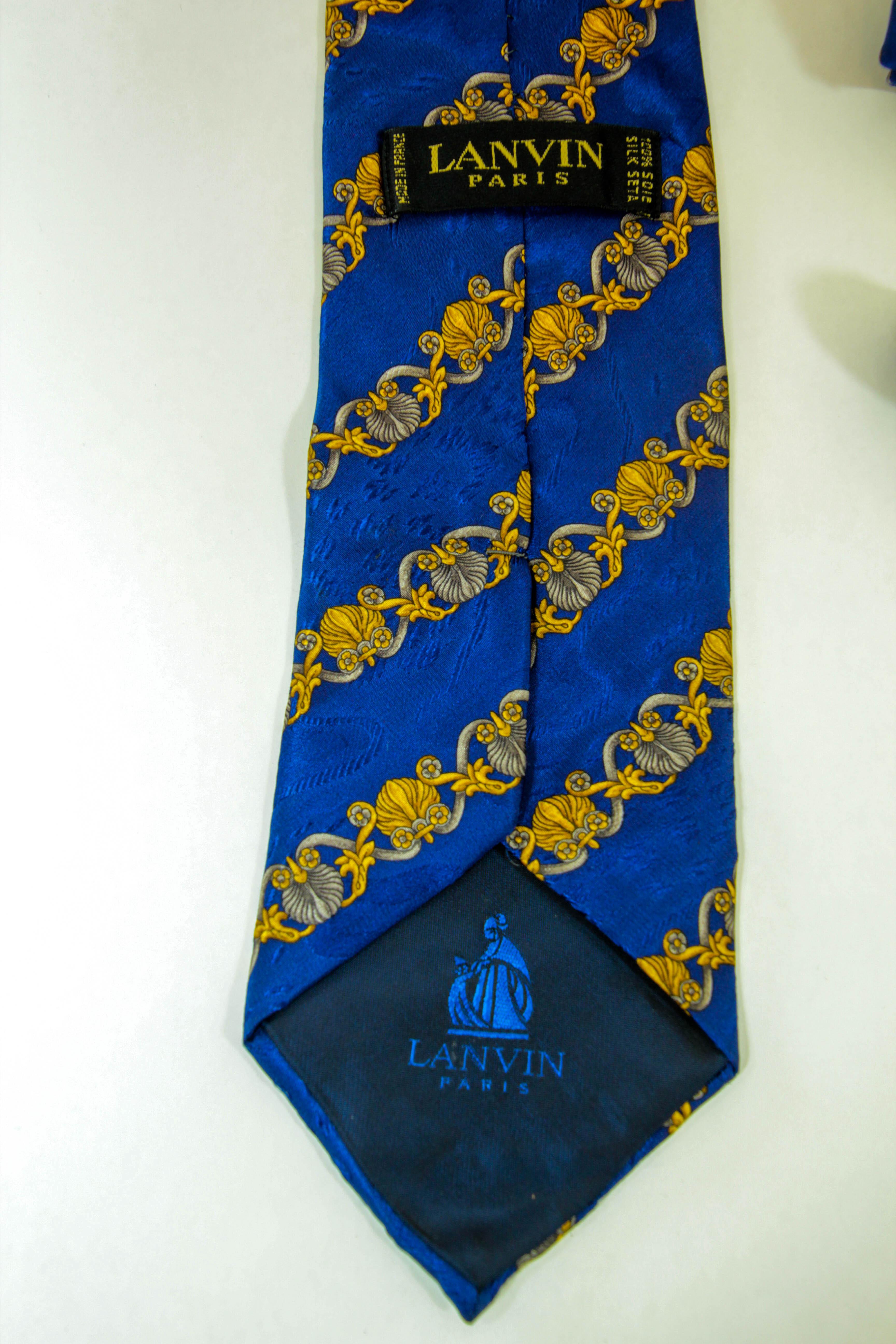 LANVIN Paris Royal Blue and Gold Silk Neck Tie, made in France.
100% silk necktie from the Maison Lanvin Paris featuring a royal blue background with baroque gold designs.
Made in France.
Good Pre-Owned Condition.
Measurements: 57
