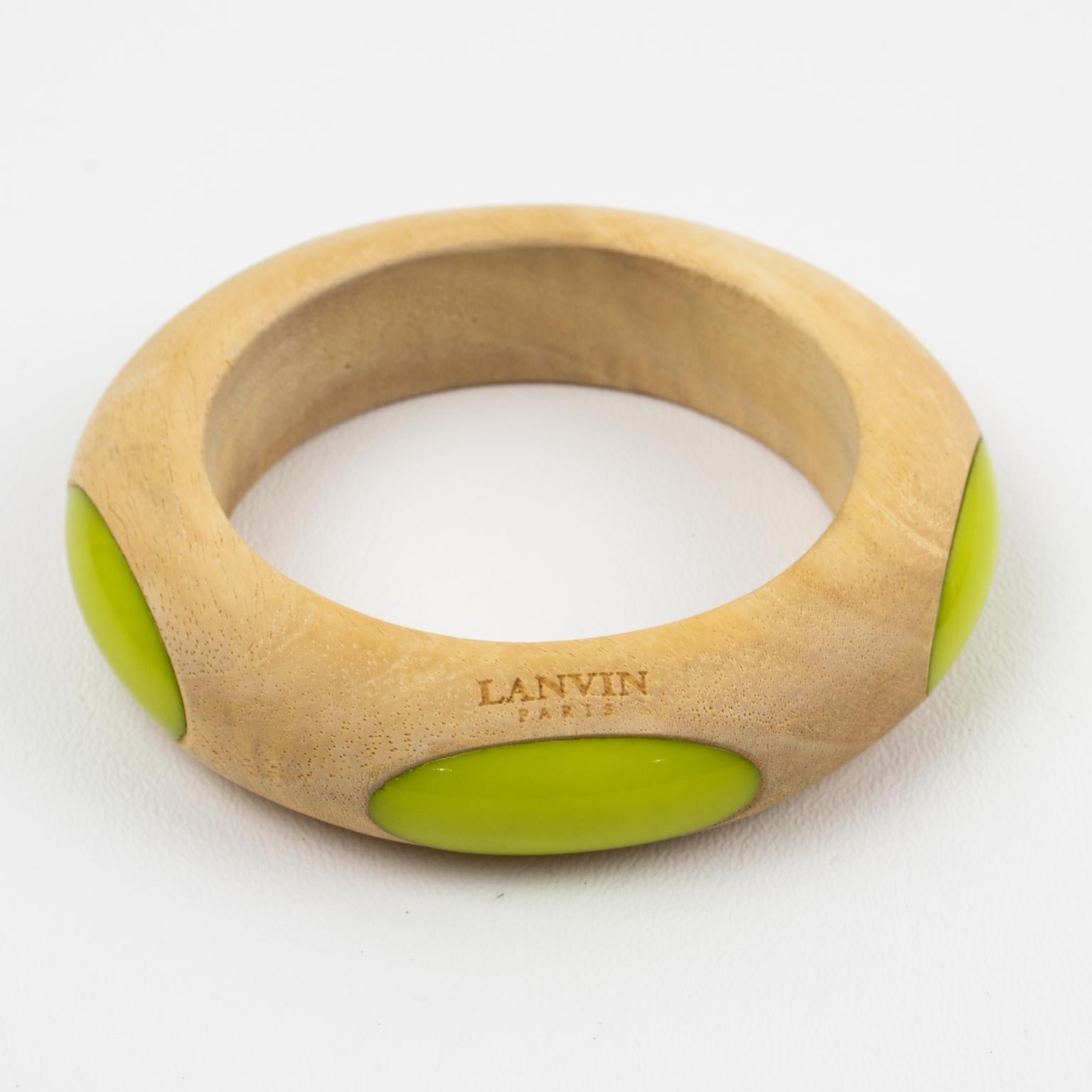 This stunning Lanvin Paris chunky Space Age or UFO flair bracelet features a light color wood bangle shape with very smooth inset ovals of resin elements. The piece boasts an avocado green color for the five resin ovoid inserts around it. Burnished