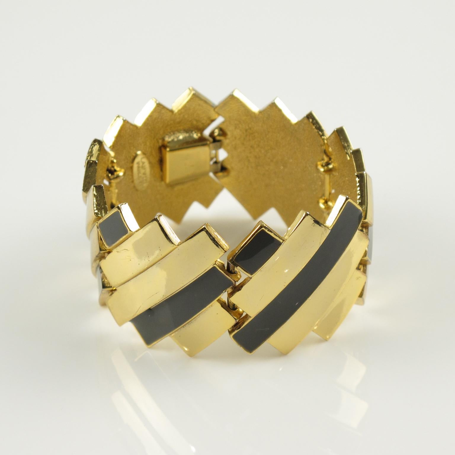 Cet élégant bracelet à maillons moderniste de Lanvin Paris est une pièce d'apparat datant du début des années 1970. Il présente un bracelet massif sculpté en métal doré au design futuriste, complété par de l'émail gris. L'étiquette dorée de Lanvin