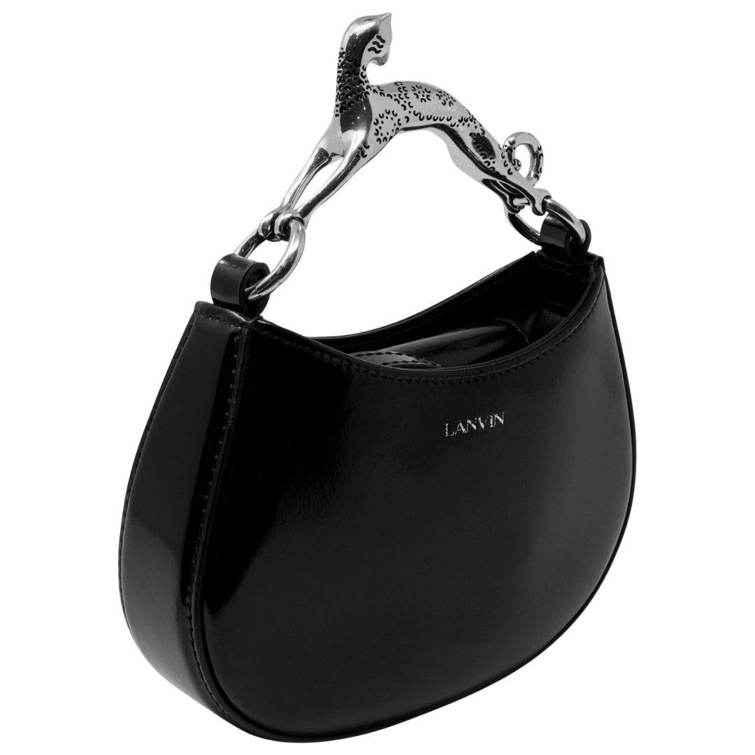 With its shiny black patent leather and contrasting silver hardware, this bag is a stylish option for any occasion. It features an open top for easy access and includes a slip pocket inside for additional storage.

SPECIFICS
• Length: 6
• Width: 4
•