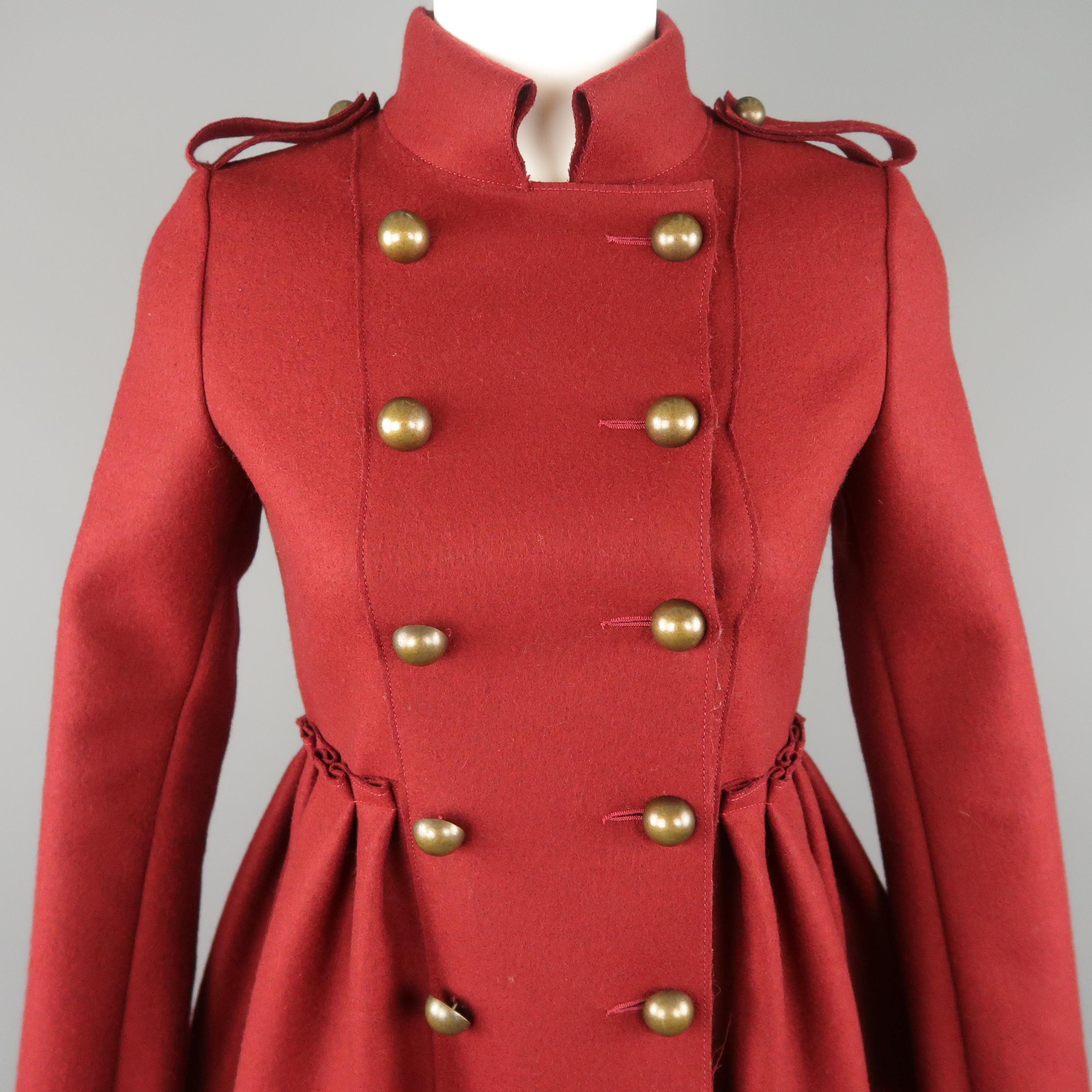 LANVIN military style coat comes in burgundy wool blend felt with a folded stand up collar, double breasted antique gold brass button front, epaulets, and gathered overlay flair skirt. Made in Italy. Retail price $ 3,998.00
 
Excellent Pre-Owned