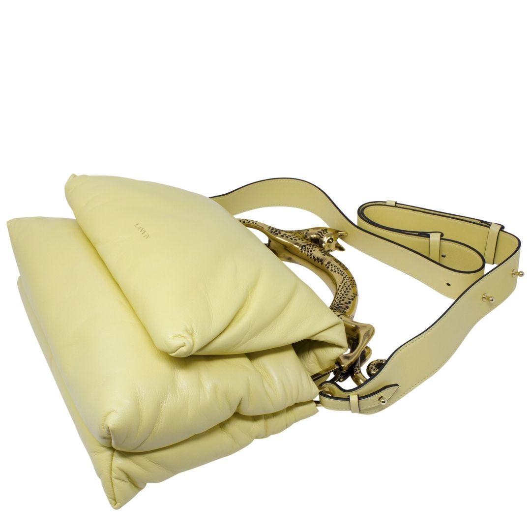 This runway beauty is for the fashionista. Crafted in soft yellow lambskin leather with a front LANVIN logo detail and a very interesting tufted pillow silhouette and an iconic cat handle. There is a zippered pocket to the back as well. The front