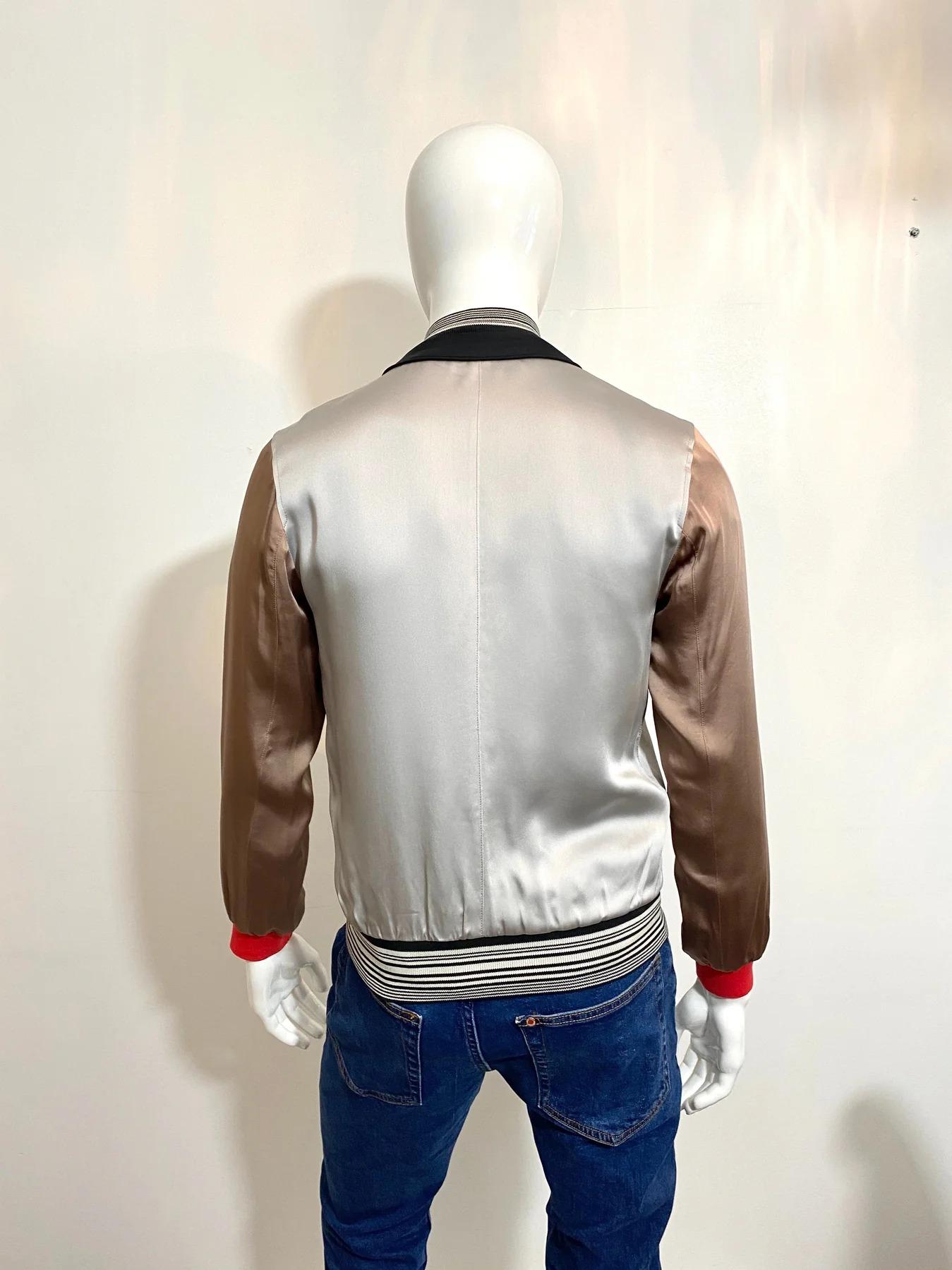 Lanvin Satin Bomber Jacket

Features a crew neck, long sleeves, front zip fastening, side zip pockets in gunmetal grey and an interior pocket. Contrasting ribbed hem cuffs in bright red with stripped neckline and hem in black and white. Taupe tonal