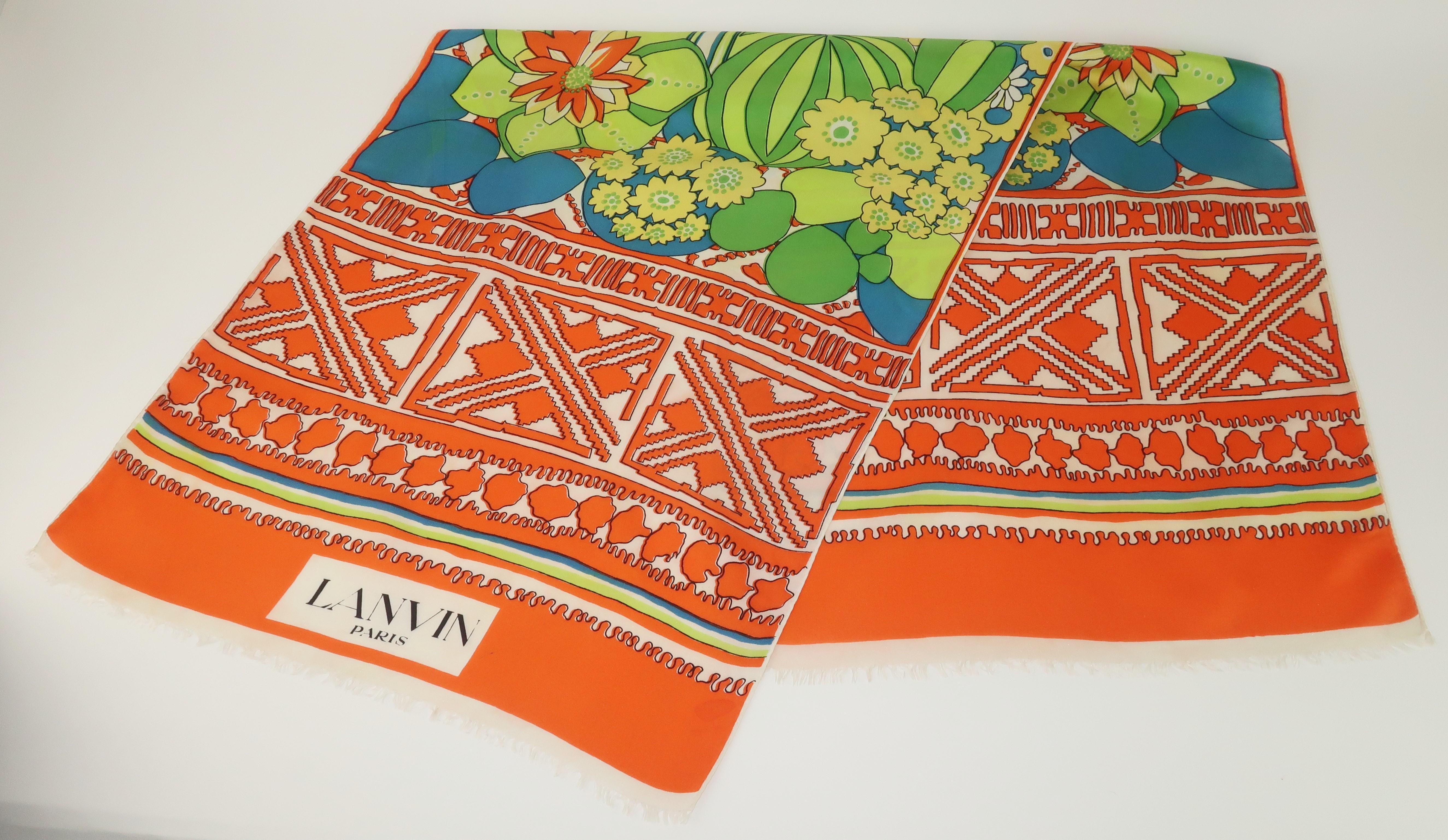 1960's Lanvin silk scarf in an extra long and dramatic length with a vibrant tropical print in shades of orange, green, chartreuse and aqua blue.  The edges are fringed and the floral pattern is framed by a graphic tribal style print.  'LANVIN