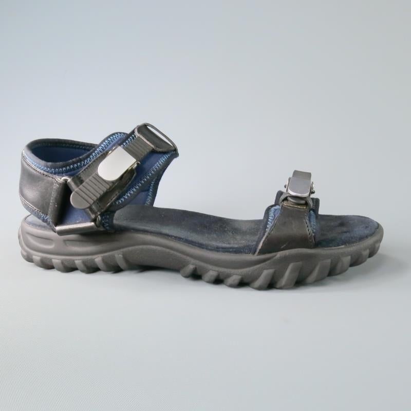 These Hybrid LANVIN athletic sandals consists of leather,neoprene and rubber material in a navy and black tone. Detailed with front adjustable straps around the front and mid-section of foot, as well Clasp-strap around the back heel. Leather accents