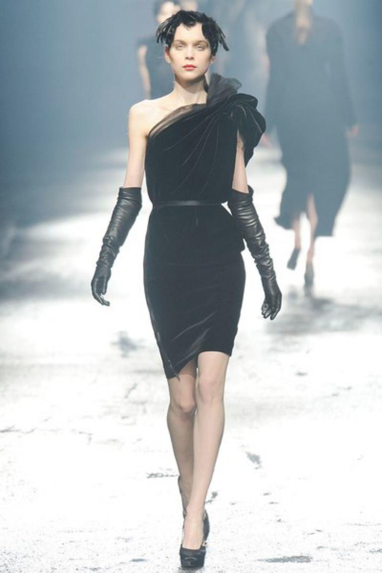 LANVIN cocktail dress from Fall 2009 Collection comes in black velvet with an asymmetrical drape, one shoulder cut with ruffled sleeve, exposed side zipper, and gathered tulle accented neckline. Made in France.
 
Excellent Pre-Owned