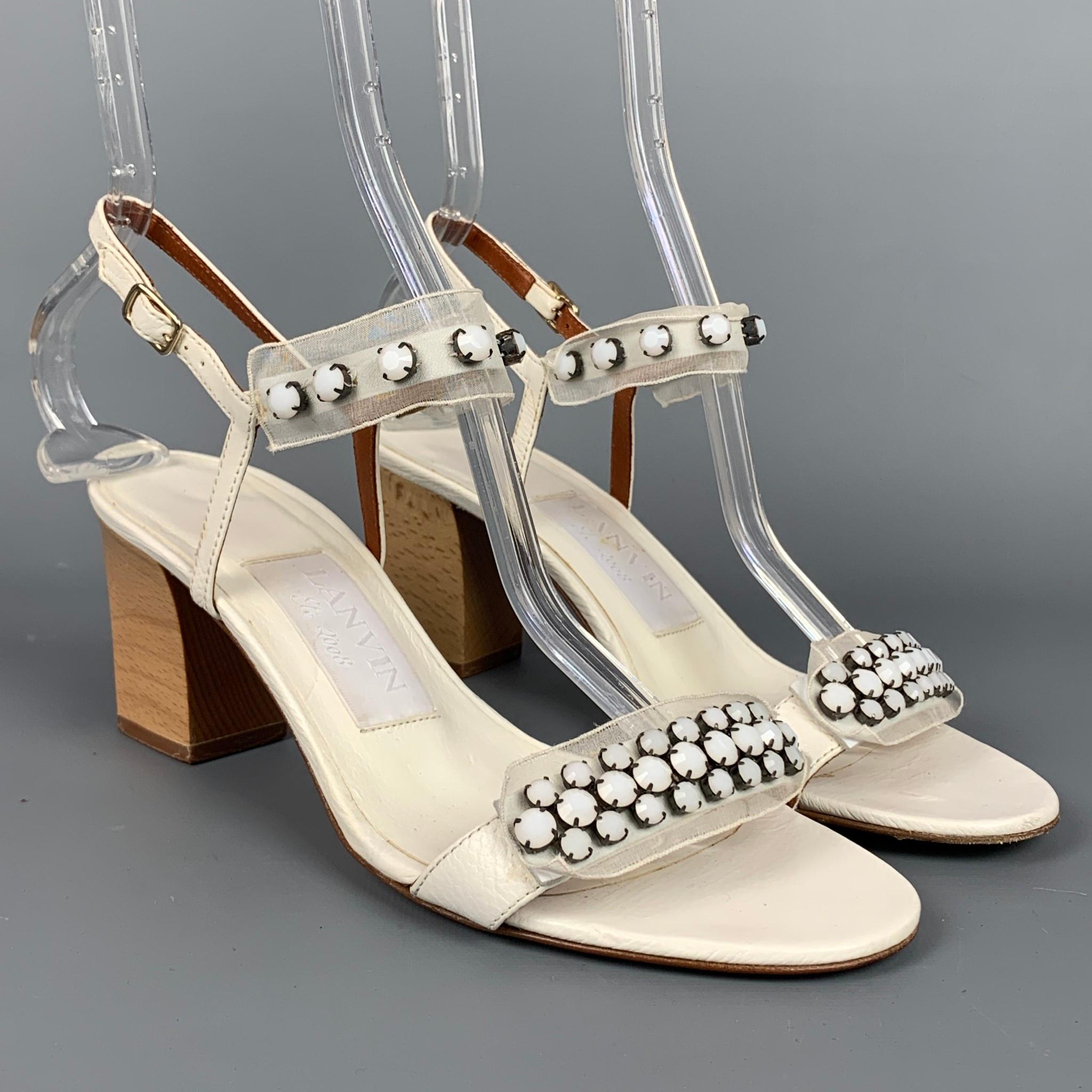 LANVIN sandals comes in a white natural leather with a silk ribbon featuring rhinestone details, strappy style, and a chunky heel. Made in Italy.

Good Pre-Owned Condition.
Marked: IT 38

Measurements:

Heel: 2.5 in.
 