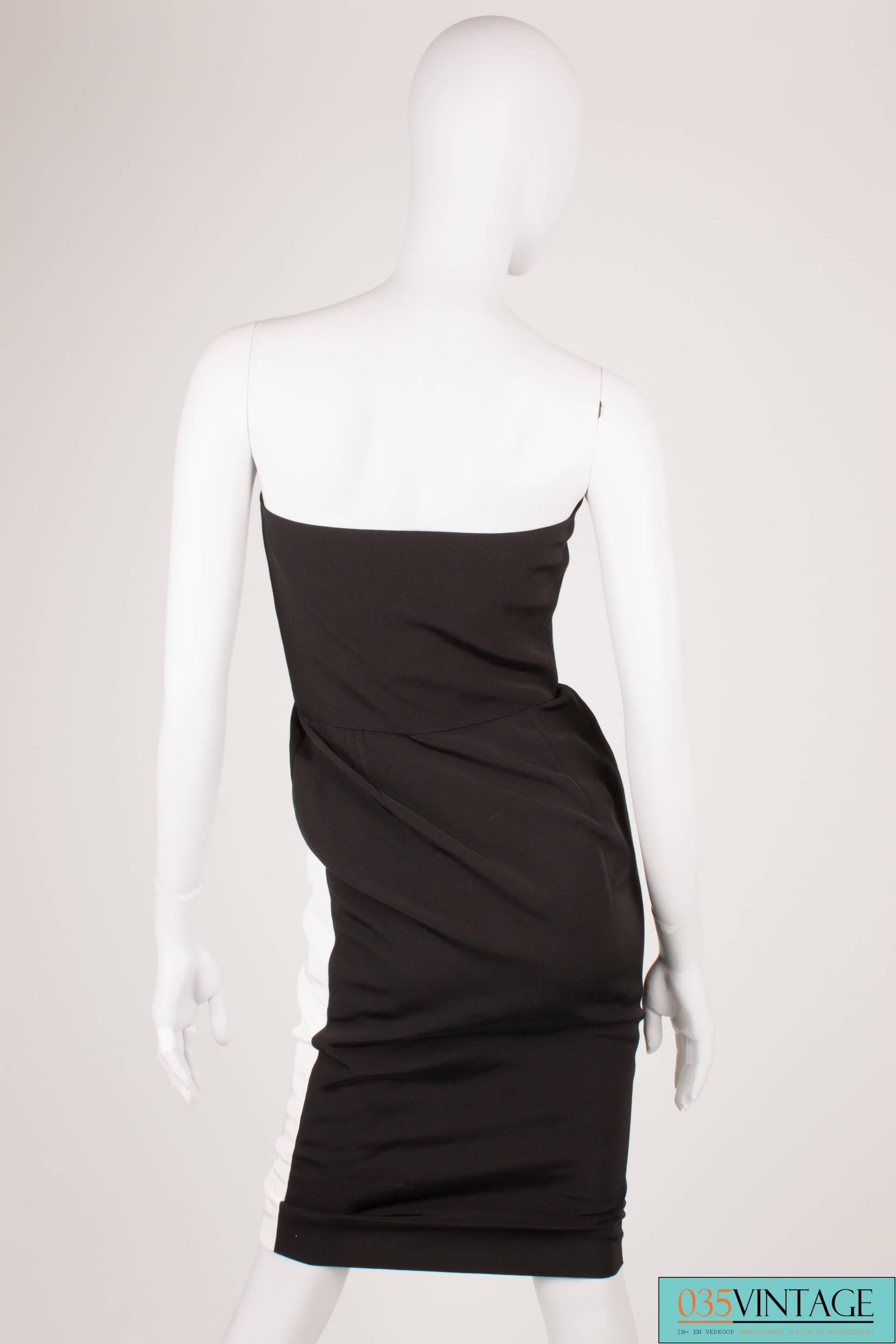 Beautiful 80's vintage dress by Lanvin in black and white, adorable!

This strapless dress has front zip closure which is hidden underneath the white part whit the black buttons. You have to unloose these buttons, before you can put it on. Very