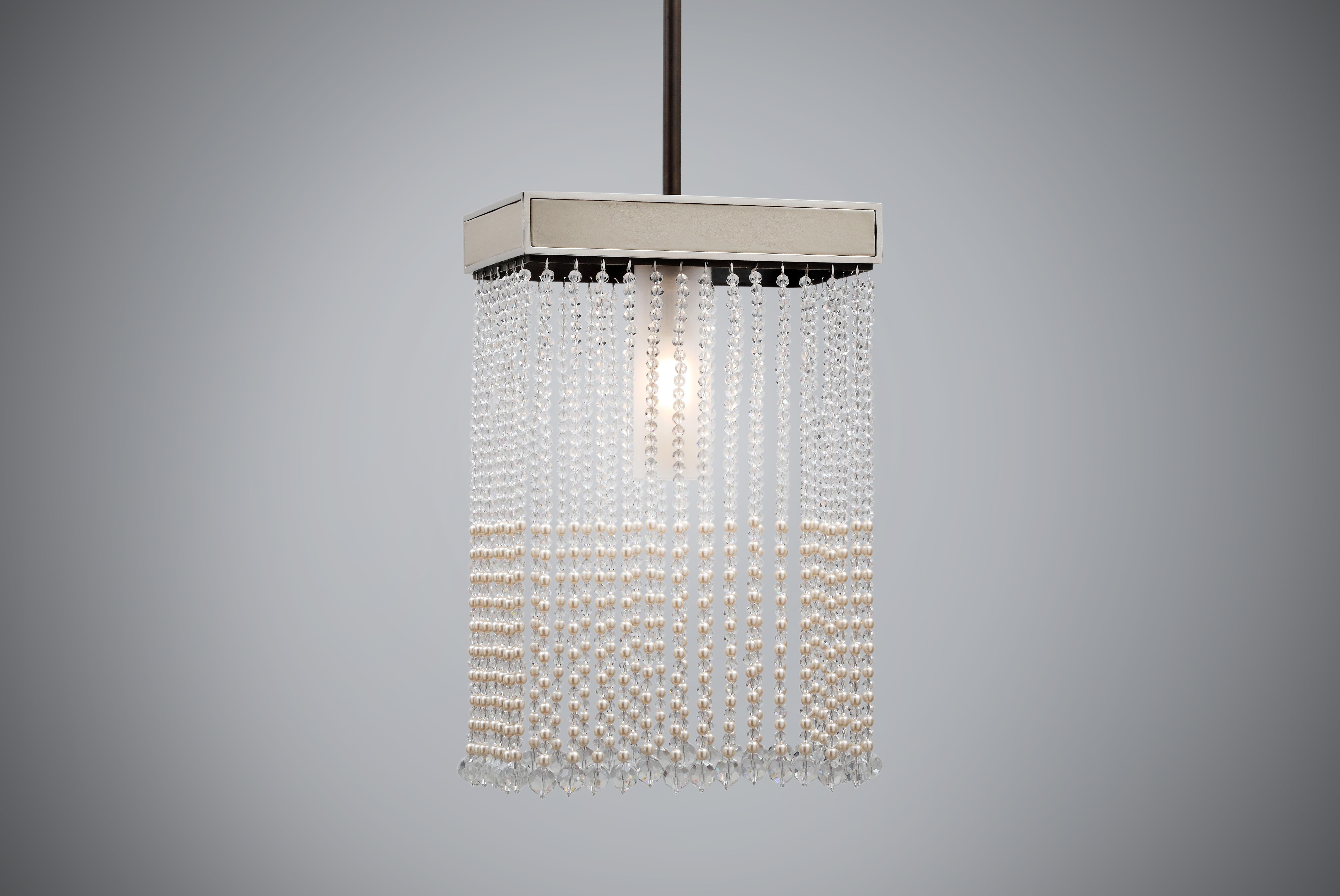 Our Lao Pendant, named after the largest pearl ever found, is handmade with the softest nubuck leather in a brass and polished nickel frame. Finished with beautiful crystal and pearl beading to give it its luxurious edge. Designed for the most