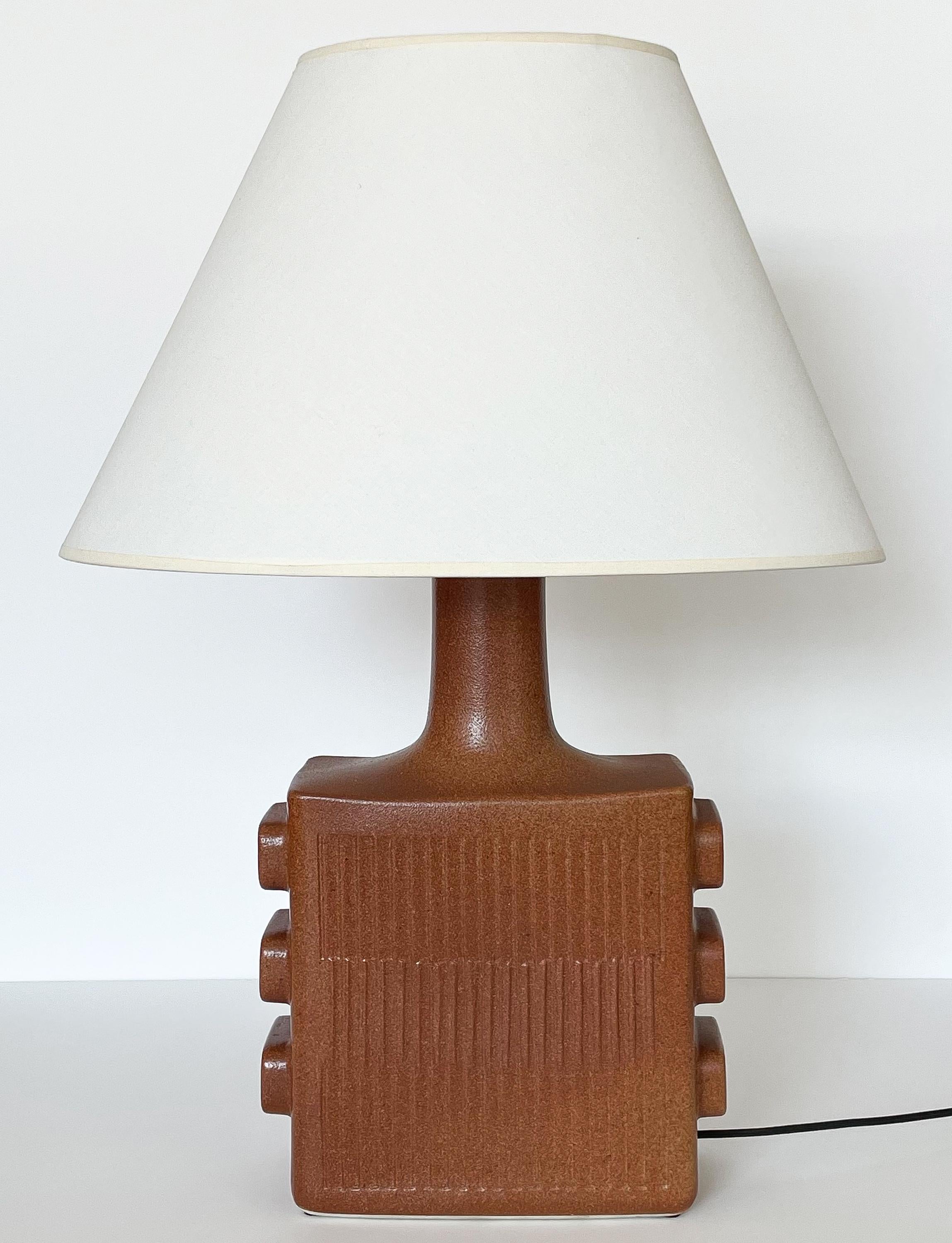 A uncommon sculptural ceramic table lamp by Lapid Pottery, Israel circa 1970s. This striking table lamp features a beautiful terracotta glaze over ceramic. The lamp has a vertical textured face and back with three rounded stylized rectangular