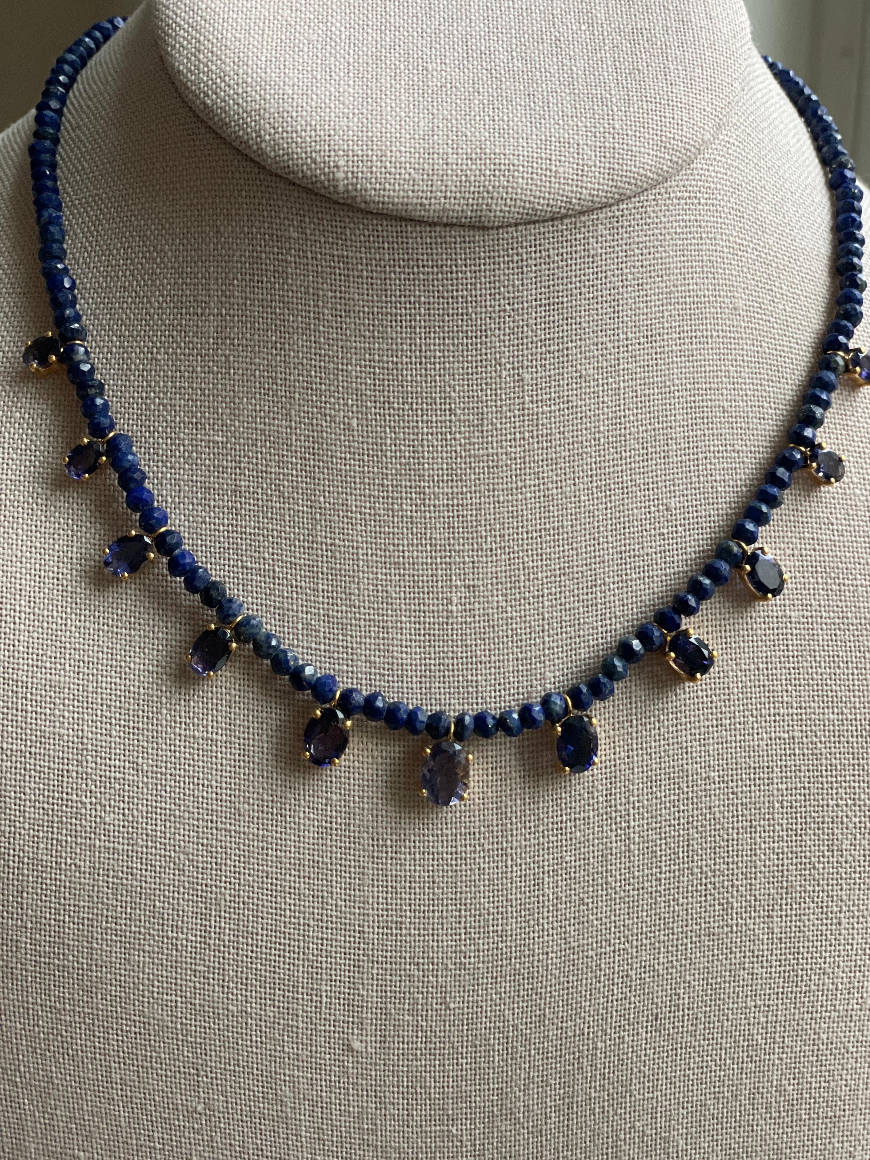 Comprised of 11 Iolite Ovals, this necklace is a blue lovers dream. The rich hues of deep blue shine and sparkle throughout this piece. The ovals graduate in size with the center stone as the largest. These Ioilte oval gemstones are set in 14K gold