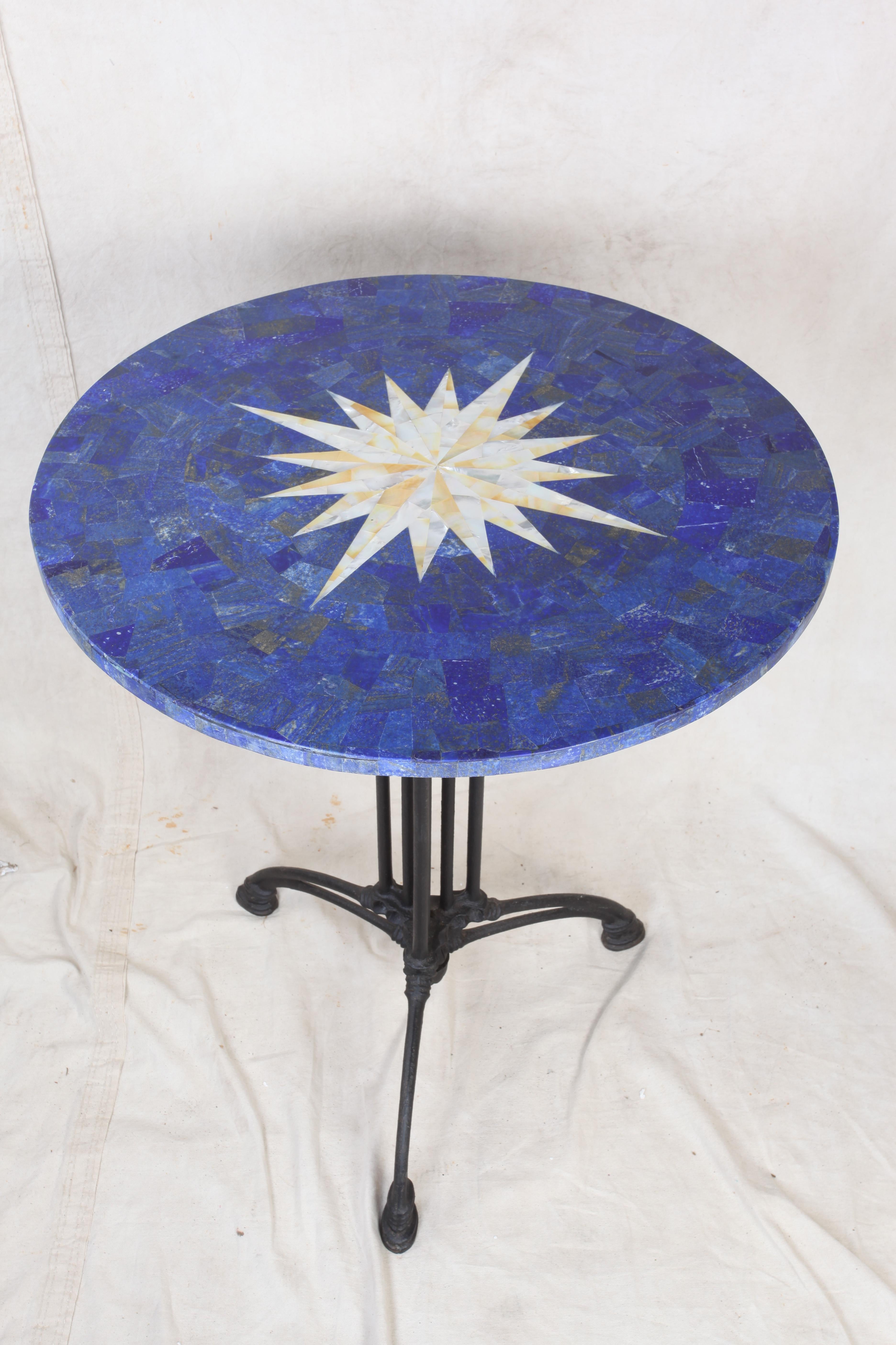 A lapis lazuli pietra dura table top with an inlay compass rose in mother of pearl. Sits on a powder coated aluminum base. Can be used inside or outside.