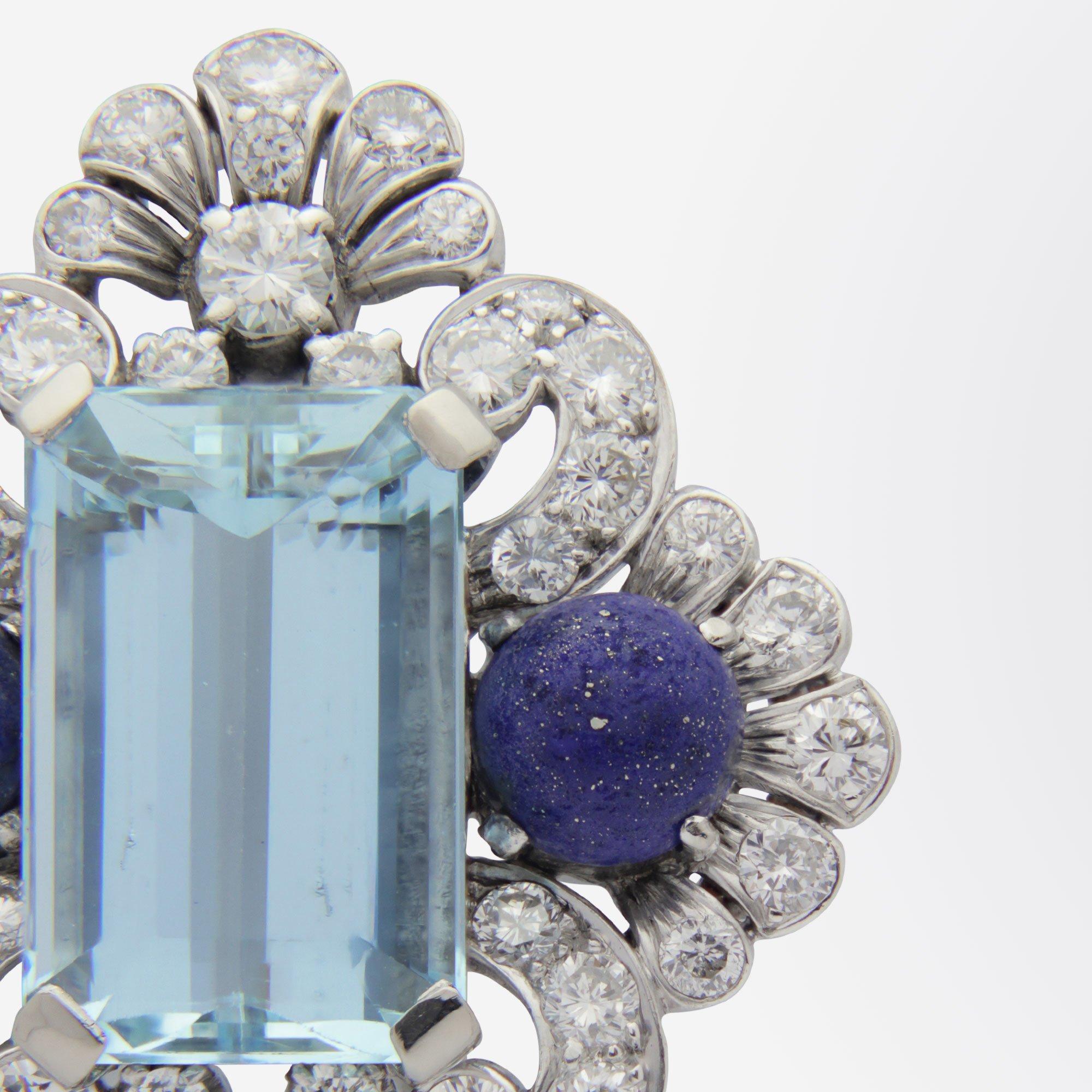 An exceptional diamond, aquamarine and lapis brooch pin set in a handmade silver setting. The piece centres on an emerald cut aquamarine of 'bright light to mid blue' colour weighing 8.15 carat. The aquamarine is flanked by a pair of cabochon pieces
