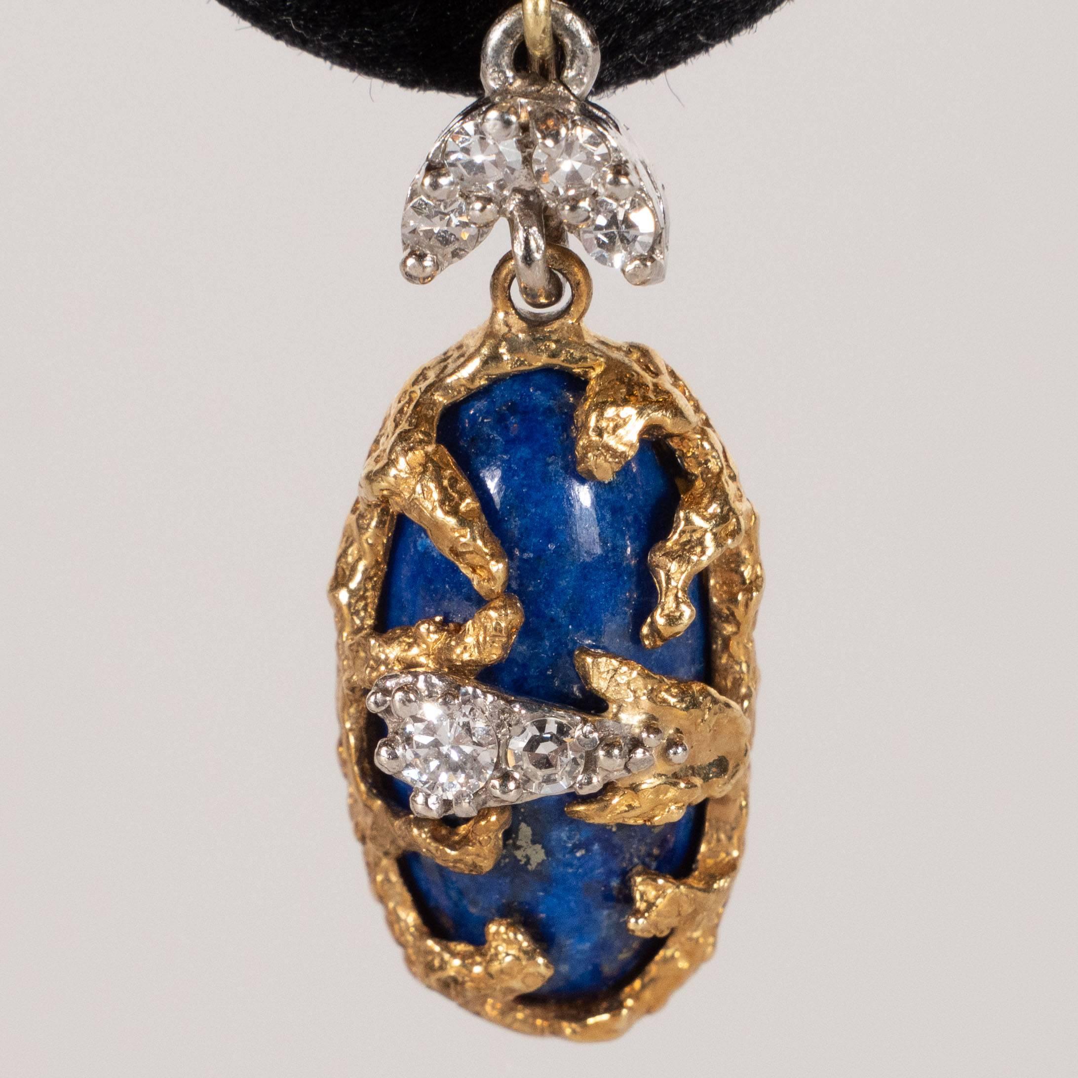This stunning pair of earrings was hand crafted by the esteemed French jewelry atelier, La Triomphe, circa 1970. They feature oval forms of lapis lazuli circumscribed by textured 18k yellow gold resembling tendrils of elkhorn coral that ensconce the