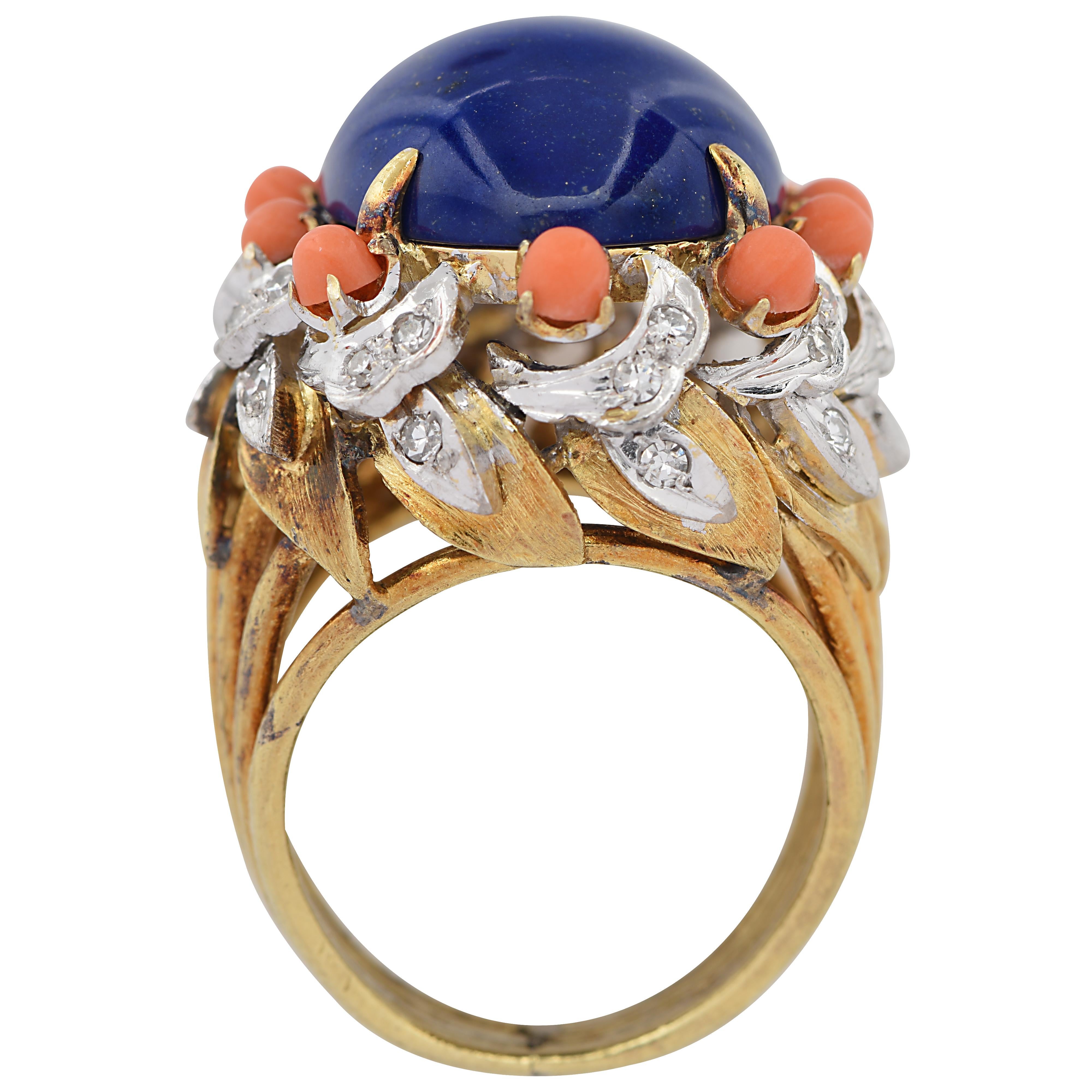 Striking cocktail ring crafted in 18 karat yellow gold showcasing a stunning blue lapis cabochon framed with coral and diamonds. This ring measures 24.95 mm in length, 20.75 mm in width and weighs 17.4 grams. This ornate ring is a size 5.5

Our