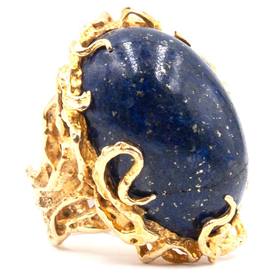 A gorgeous 14K yellow gold ring with a large Lapis Lazuli focal point. Features an ornately decorative design on this yellow gold band. Ring is hallmarked  on the  interior 
