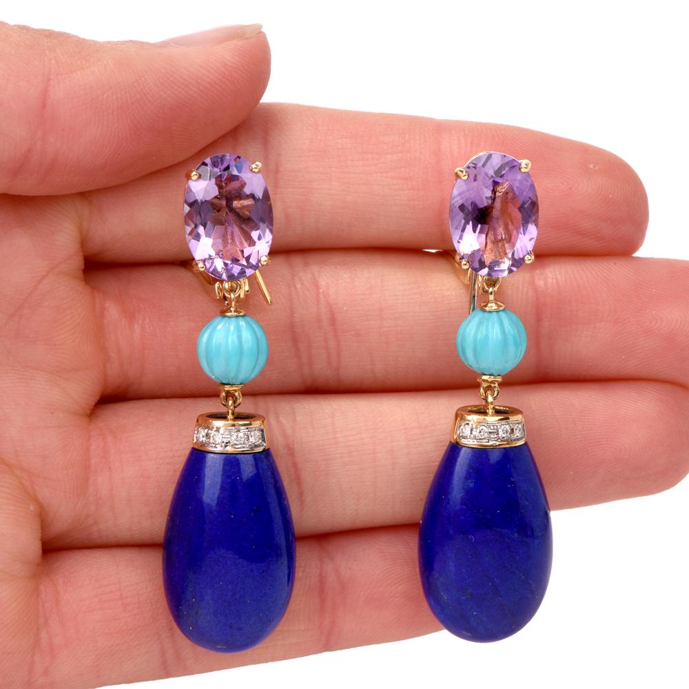 These funky lapis lazuli, amethyst, turquoise and diamond dangle earrings are crafted in solid 18K yellow gold. Dangle earrings feature 2 prong-set oval shape cut amethyst approx. 7.50 carats each connected to 7mm carved turquoise beads dropping to
