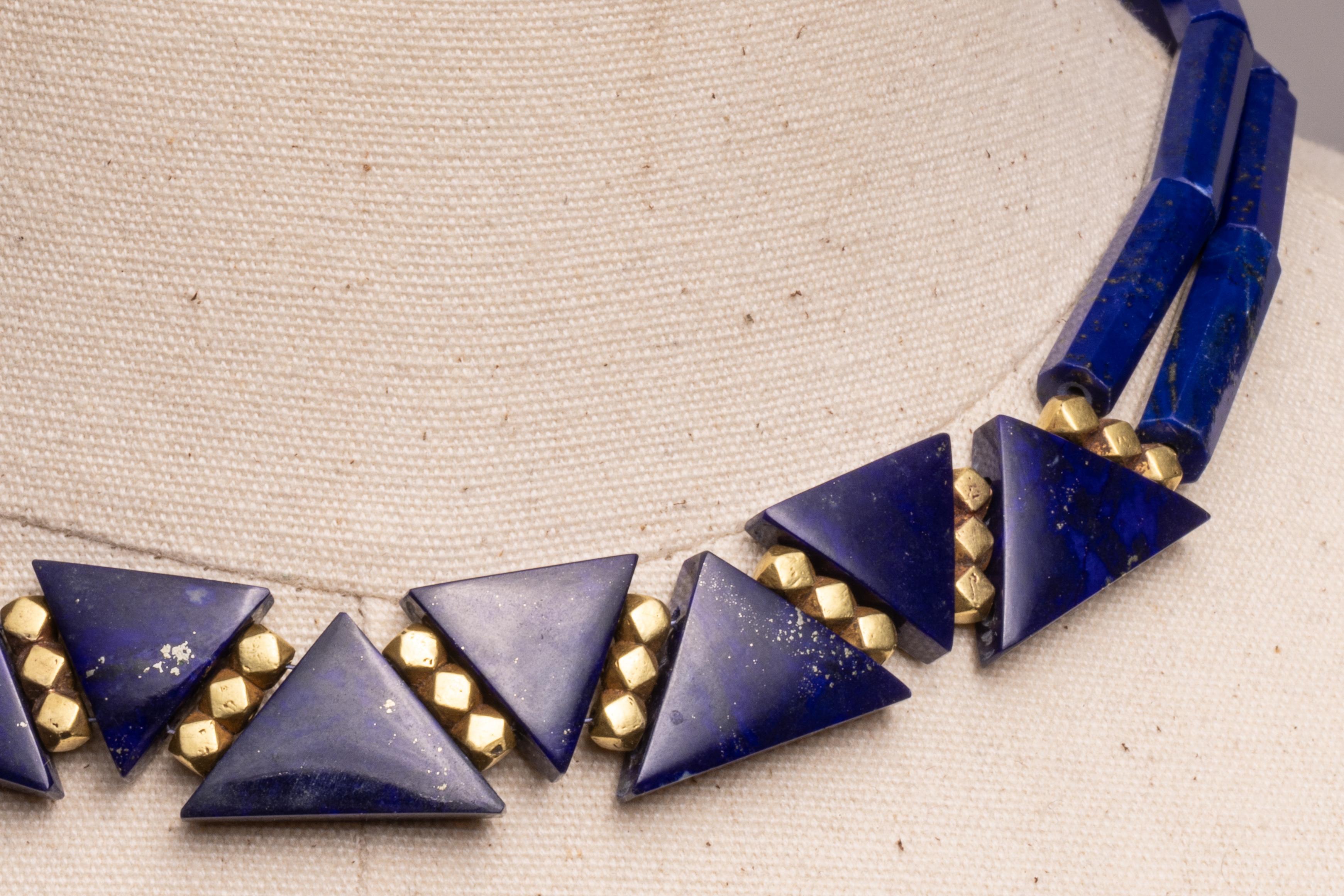 Insolite perle di lapislazzuli a taglio triangolare separate da distanziatori in oro 18 carati con perle tubolari di lapis smussate lungo il retro.  Chiusura a moschettone in oro 18 carati.  Di Deborah Lockhart Phillips.

La collezione di alta
