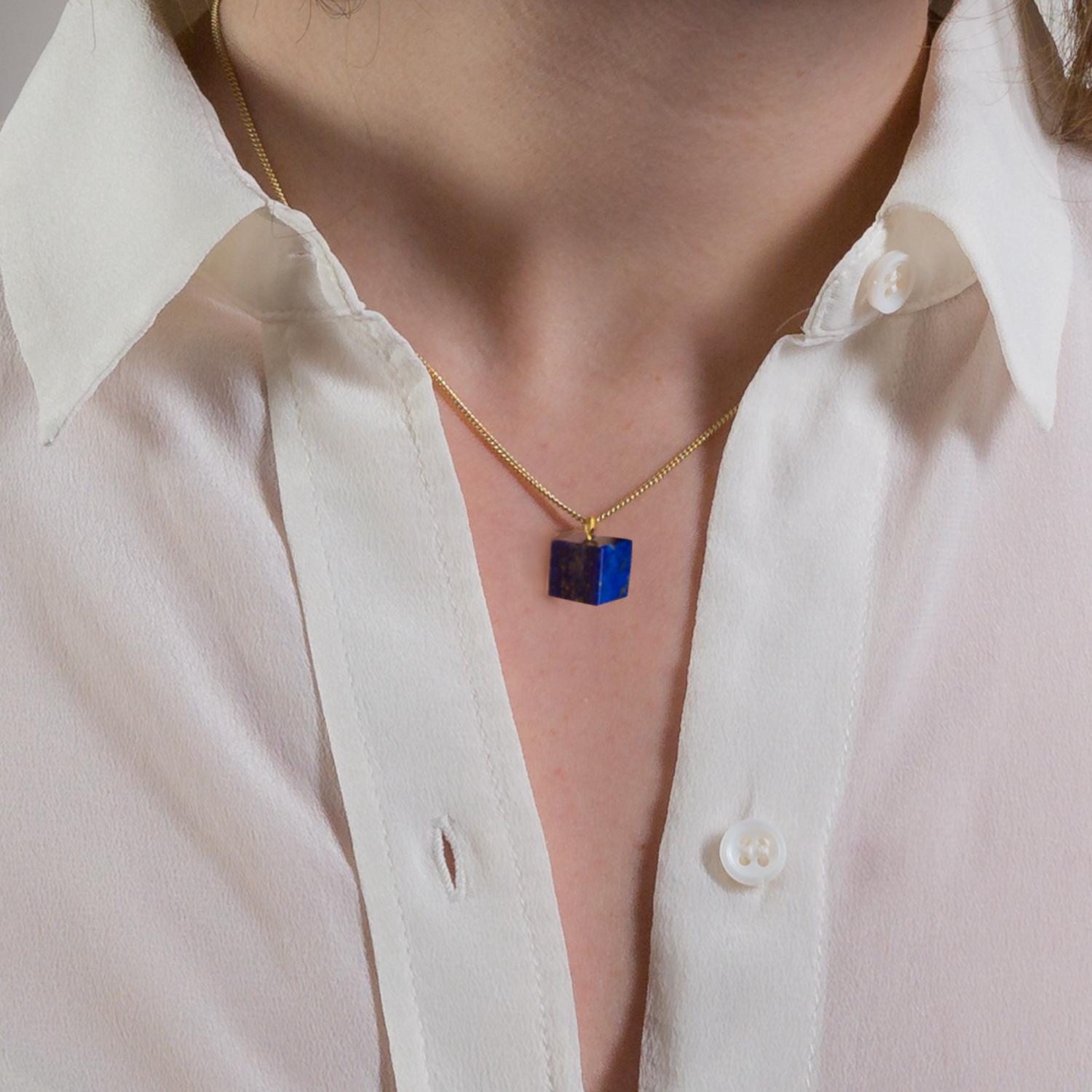 Simple and colourful, this Lapis Lazuli and Gold cube necklace is handmade in the UK. Hand carved from vibrant Lapis Lazuli the cube shape is set to fit on a 45cm long 9 karat gold necklace.

Lapis Lazuli is perhaps the best known gemstone. A