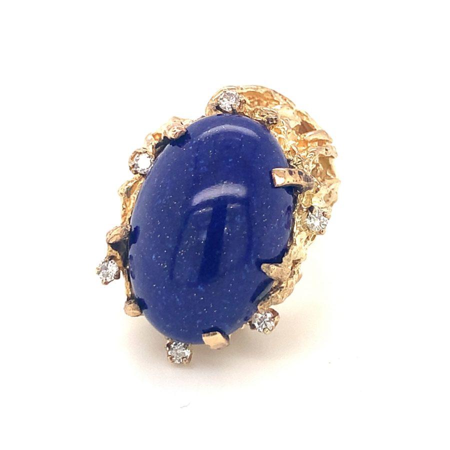 One lapis lazuli and diamond 14K yellow gold ring featuring one oval cabochon lapis with a gold nugget style mount. Enhanced by 6 transitional round brilliant cut diamonds totaling 0.15 ct. Circa 1960s.

Velvety, naturalistic,