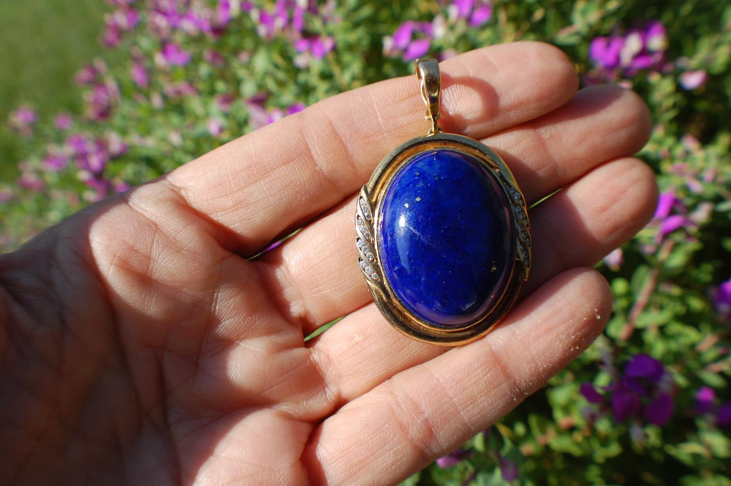  Lapis Lazuli and Diamond Pendant or Enhancer 

14 karat yellow gold bezel surrounded by diamonds displays a  large Lapis Lazuli measuring 1.50 inches. This pendant can be used as an enhancer measuring  .50 inch for a large chain attachment.

 The