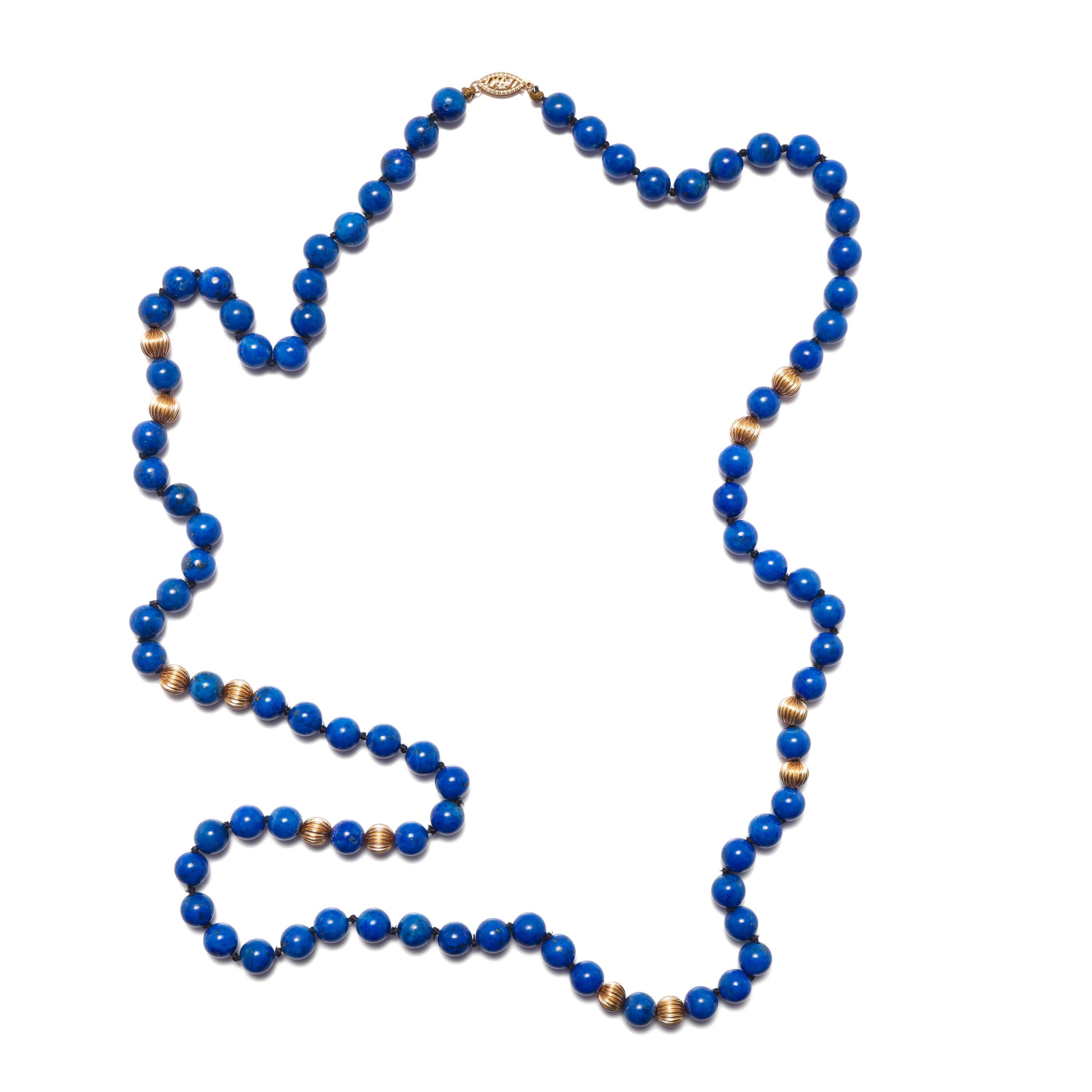 This gorgeous circa 1970s necklace is composed of ninety-two 8mm natural hand-carved and hand-polished Lapis Lazuli beads, punctuated with a dozen fluted 14K yellow gold beads. A 14k yellow gold filigree clasp completes the piece. The clasp is