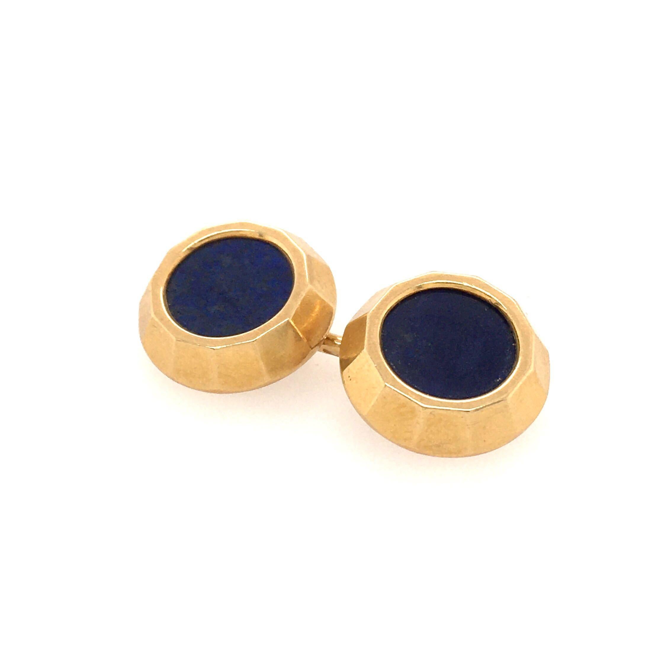 A pair of 18 karat yellow gold and lapis lazuli cufflinks, French. Circa 1960. Each double link designed as a circular lapis lazuli disc, within a faceted gold bezel. Diameter is approximately 1/2 inch, gross weight is approximately 12.9 grams. With