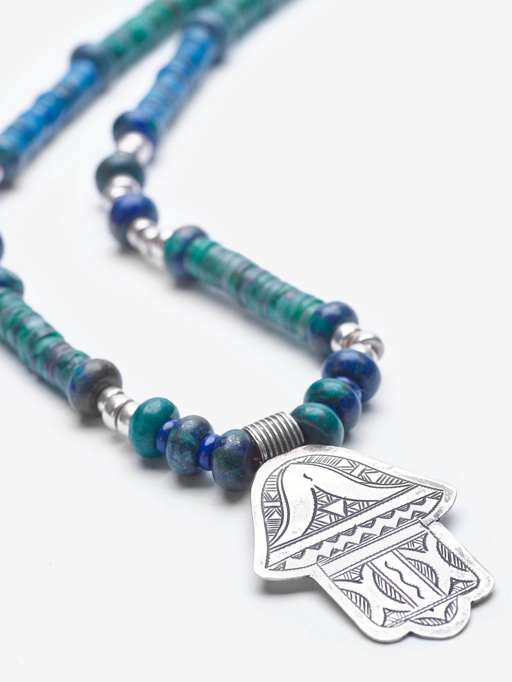 This Hand of Fatima (Hamsa) pendant was found in the souks of Fez, Morocco, in a 45 year old store. The Hamsa is a protective talisman that brings good fortune. The necklace is adorned with green jade, lapis lazuli, and chryscolla. Hayat means life,