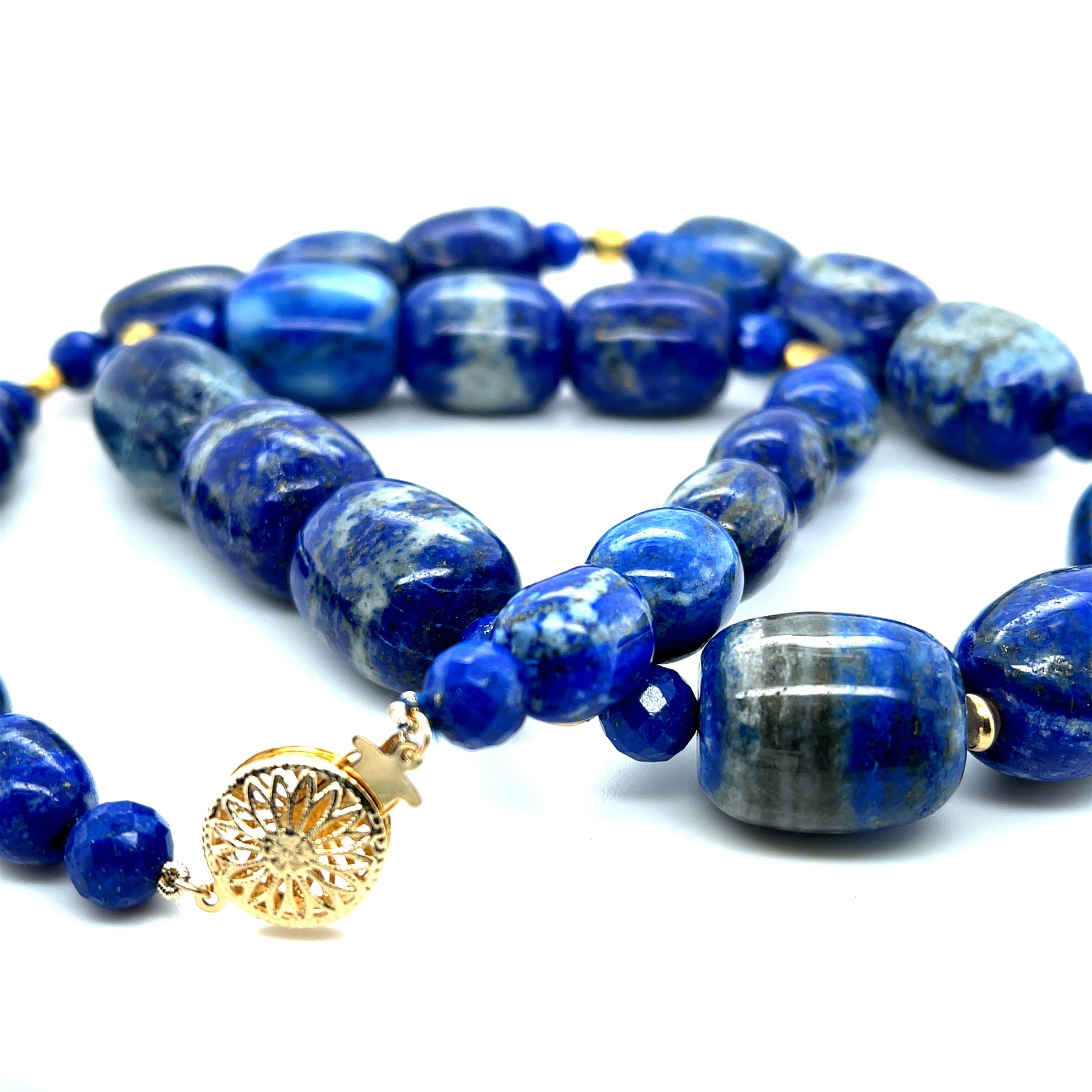 This beautiful necklace features unusual barrel-shaped lapis lazuli beads in graduating sizes, all with gorgeous Royal blue color and characteristic pyrite and calcite veining. The barrel-shaped beads have been arranged and strung on silk thread