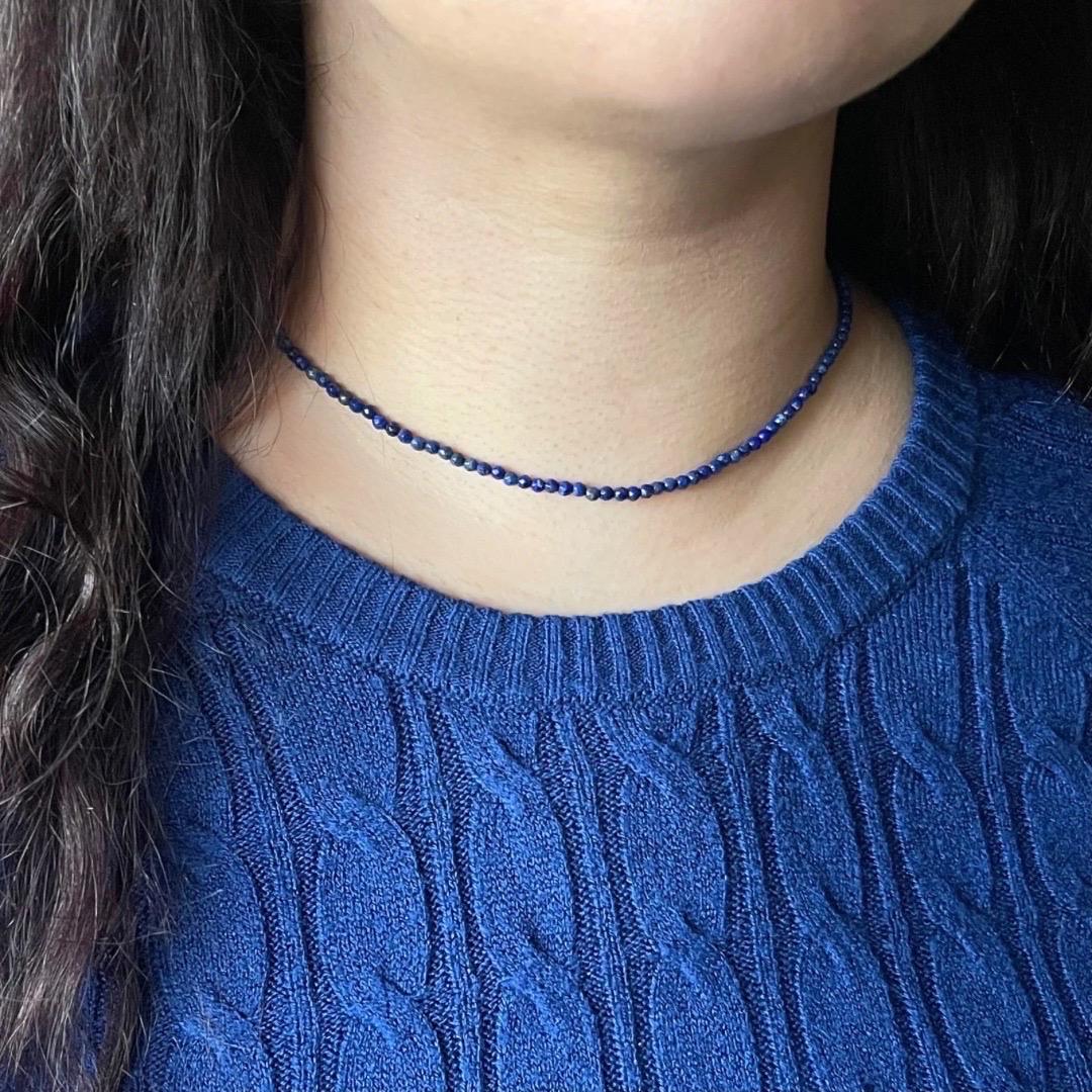 Elegia il tuo stile con questa vibrante collana a girocollo con perline di lapislazzuli, realizzata meticolosamente a mano con cura ed eleganza. Ogni perla di lapislazzuli naturale rivela profonde e ricche sfumature blu, punteggiate di pirite